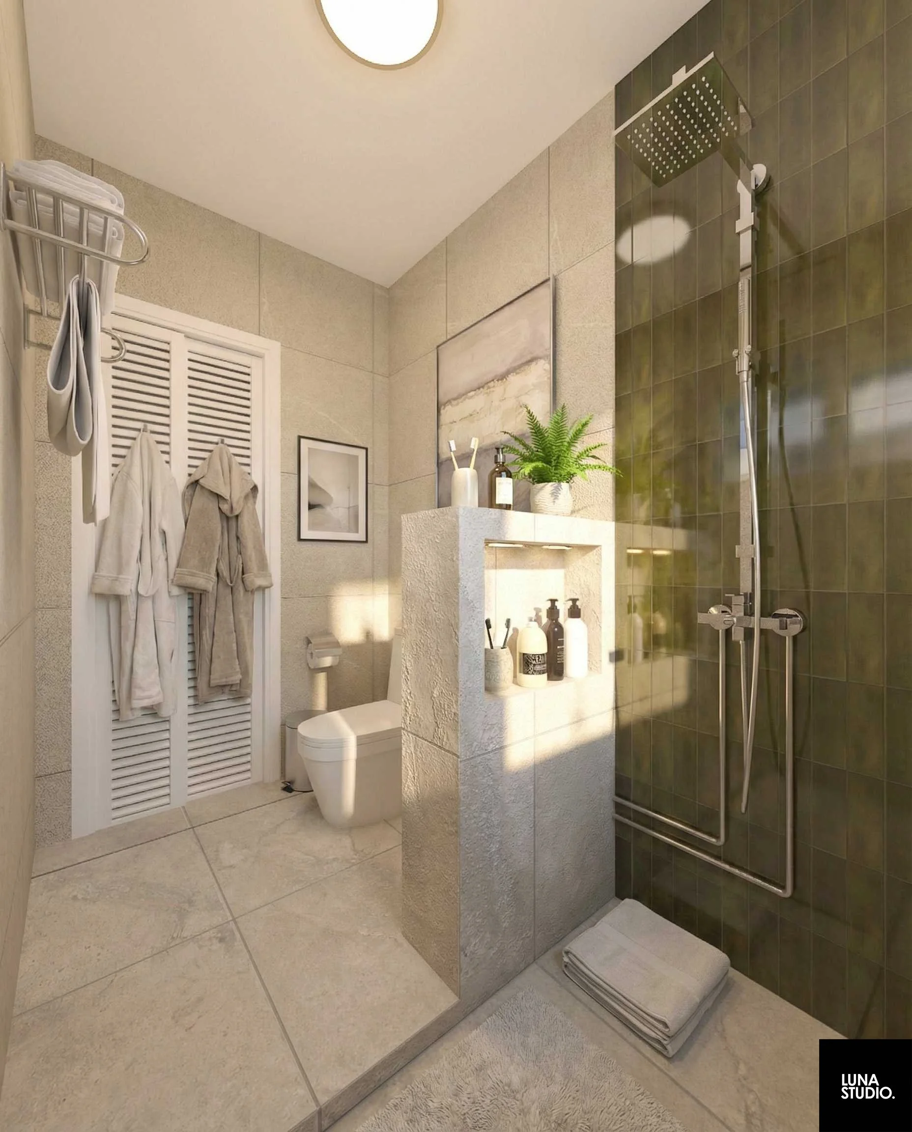 Bathroom with a toilet, a shower area with green tiles, a half wall with bathroom products, a shelf with decorative items, and towels hanging on a wall-mounted rack.