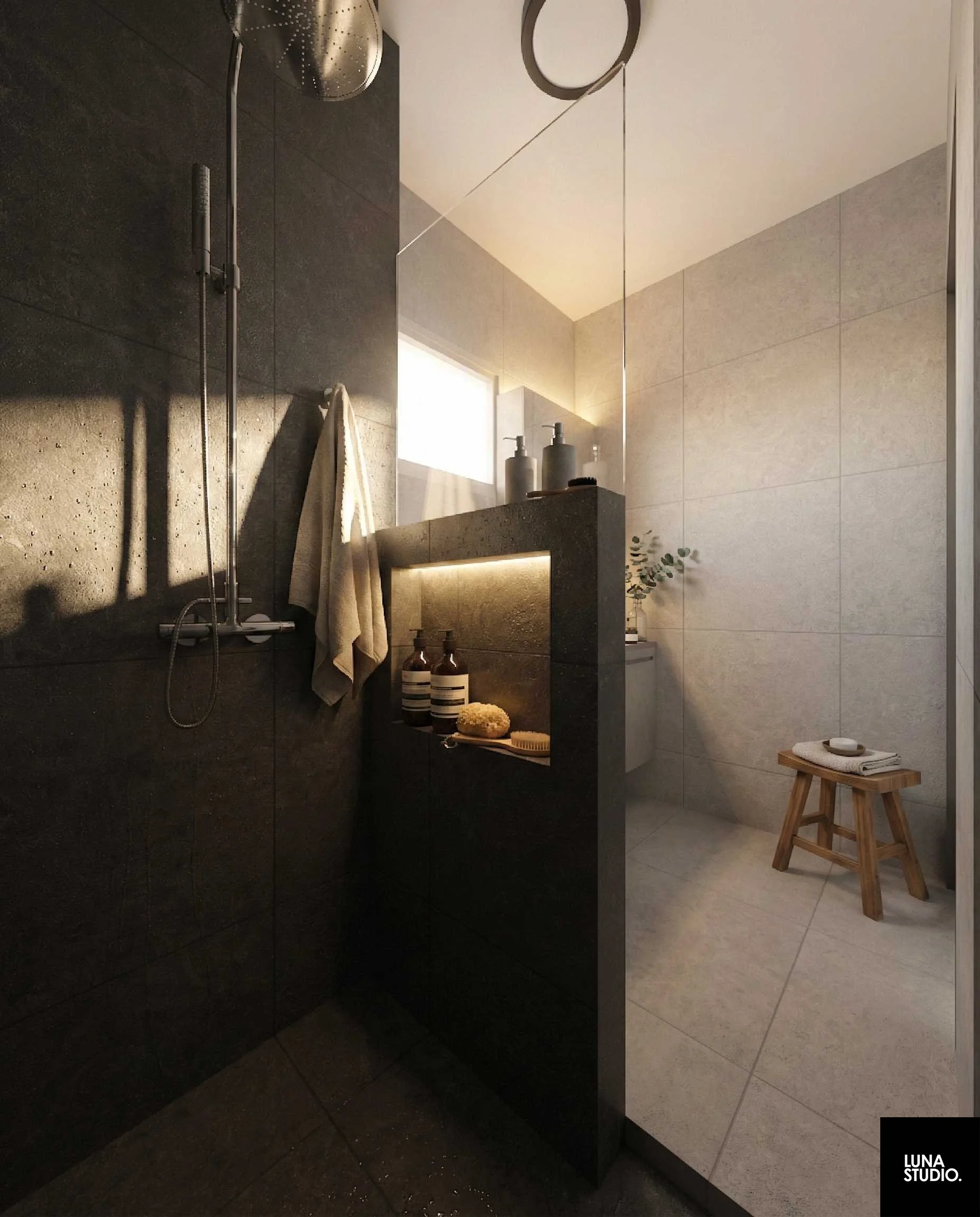 A modern bathroom with a walk-in shower and a small wooden stool with towels and soap. The shower has a rain shower head and a beige wall, while the rest of the bathroom has dark and light tiles. There are bottles and a bath brush on a ledge.