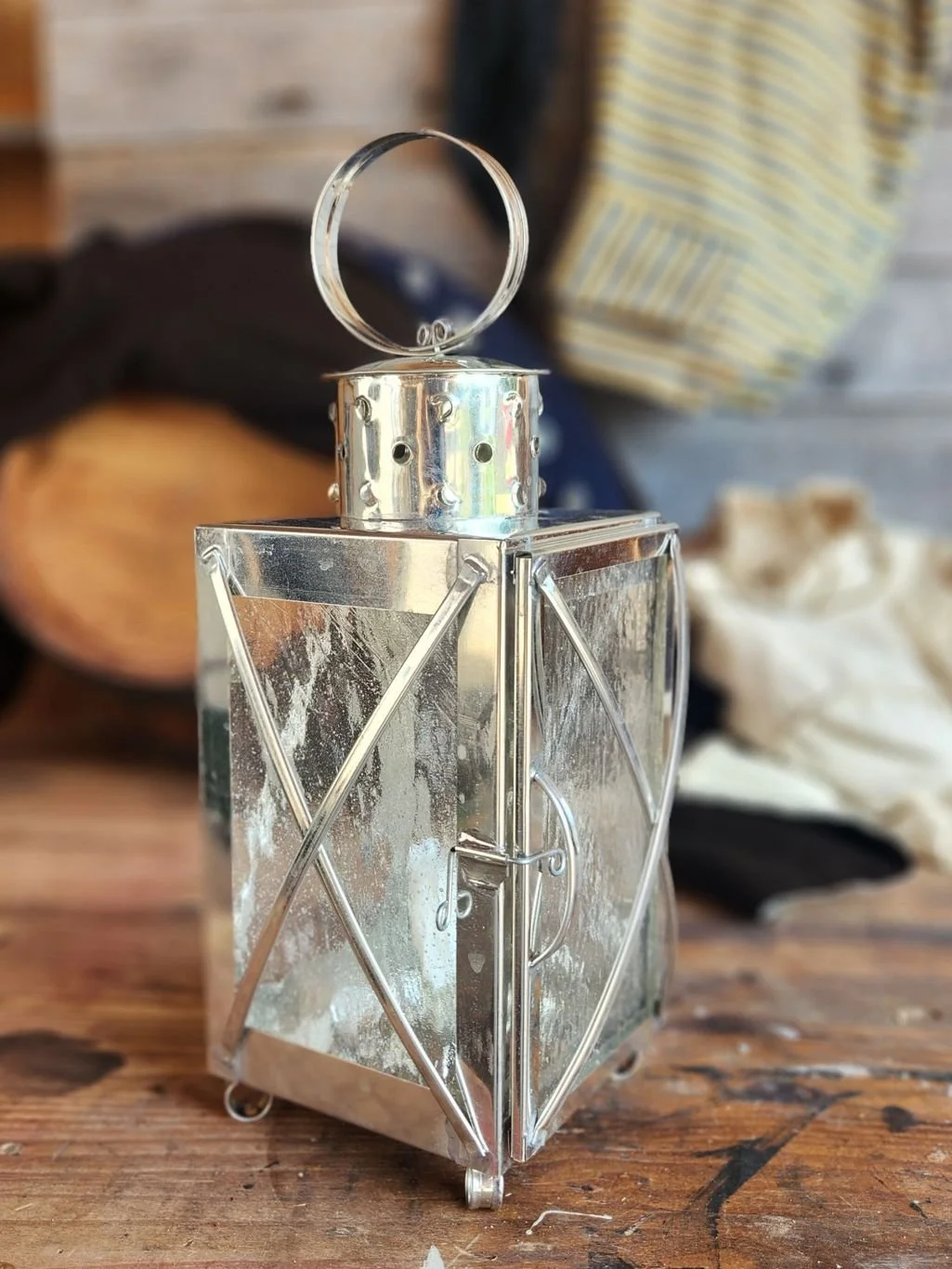 Small square bright tin candle lantern with crossed glass guards.