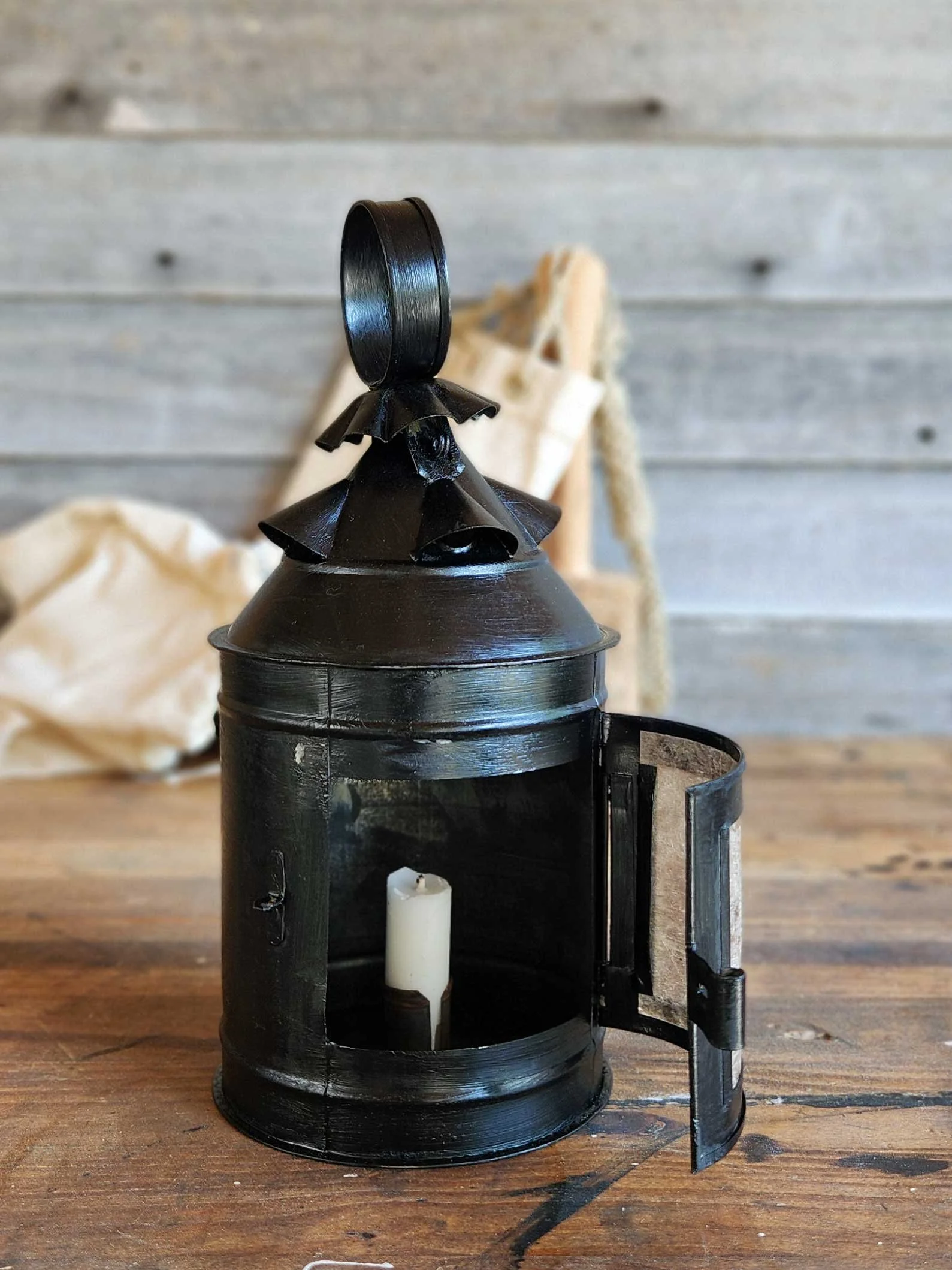17th-century tin lantern with black paint and lite panes.