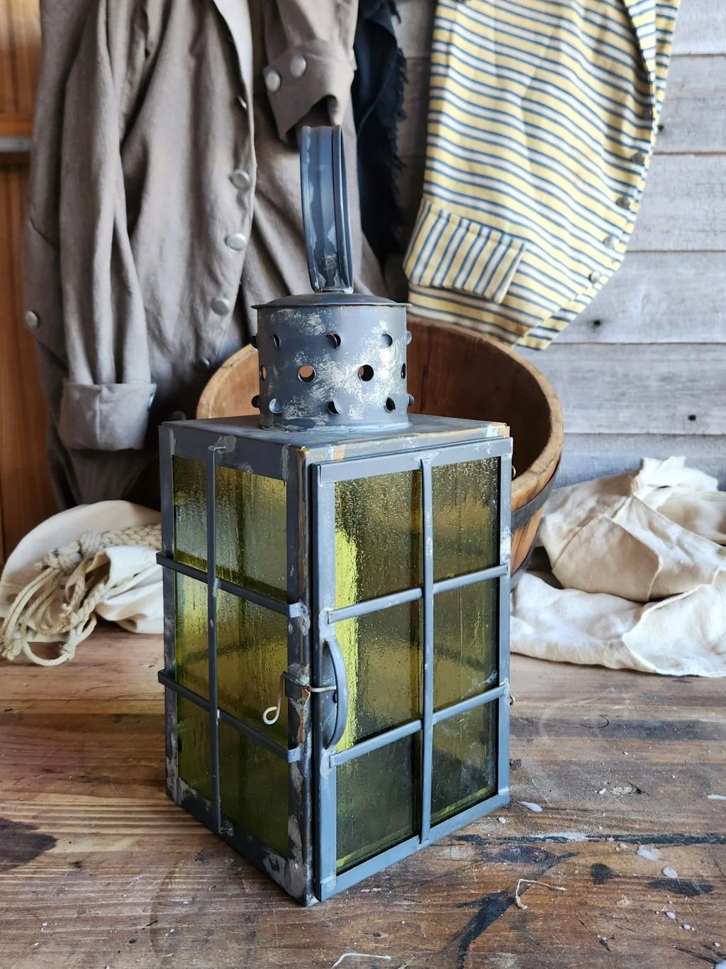 Square tin candle lantern with a round carrying ring and double rows of glass guards.