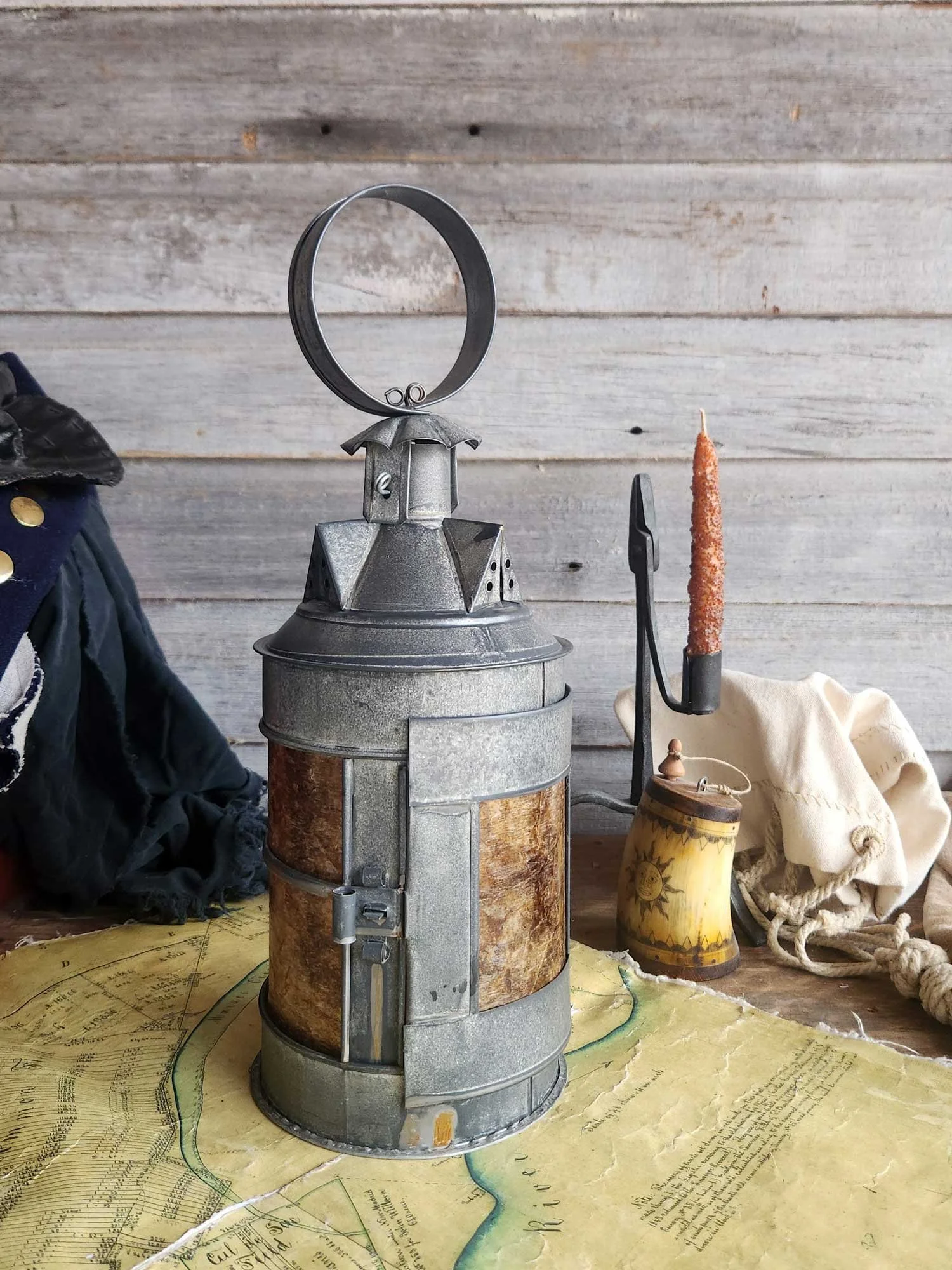 Hanging barn lantern with pointed dormers and amber panes.