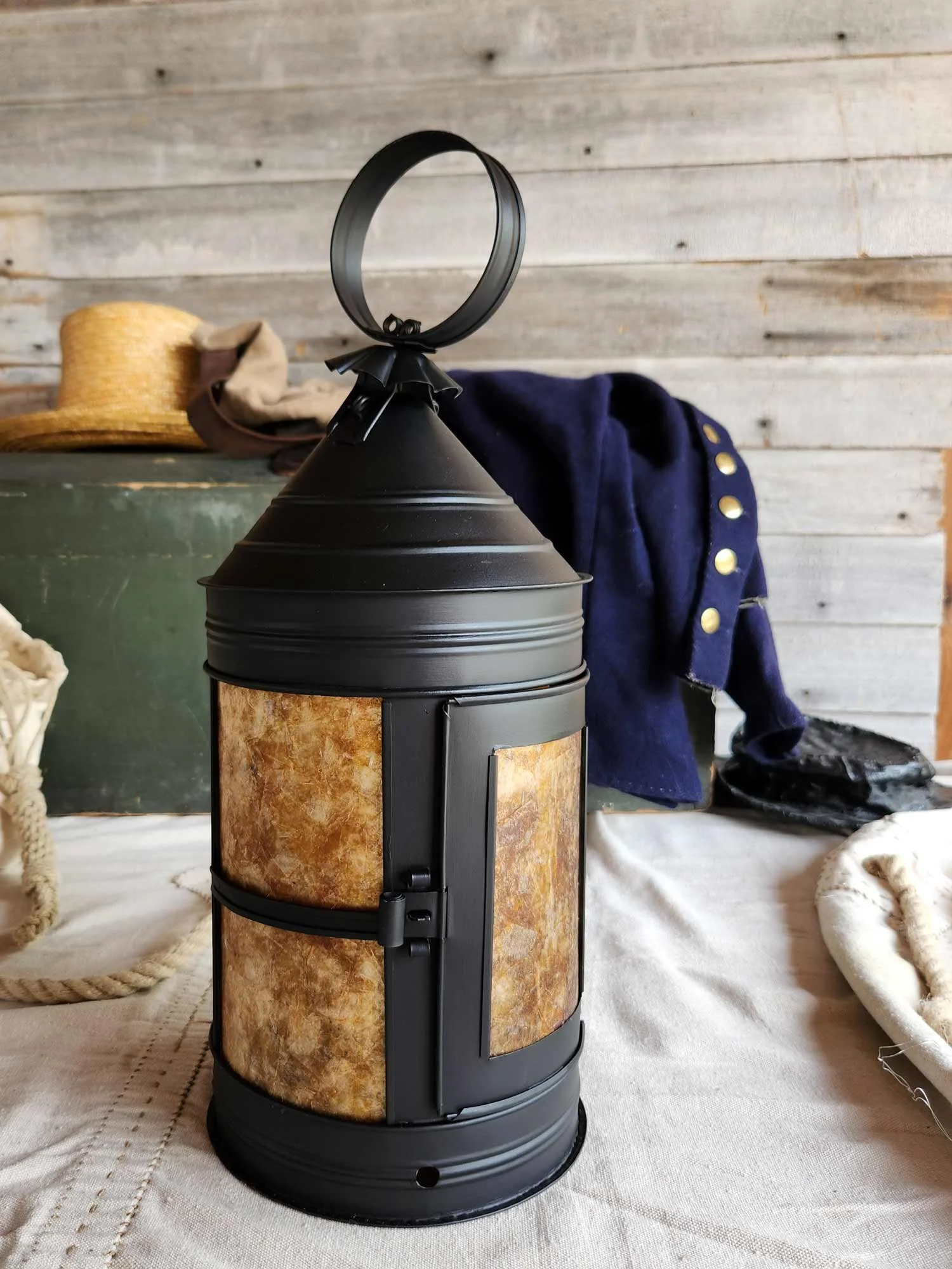 A sturdy black 18th-century naval lantern with amber panes
