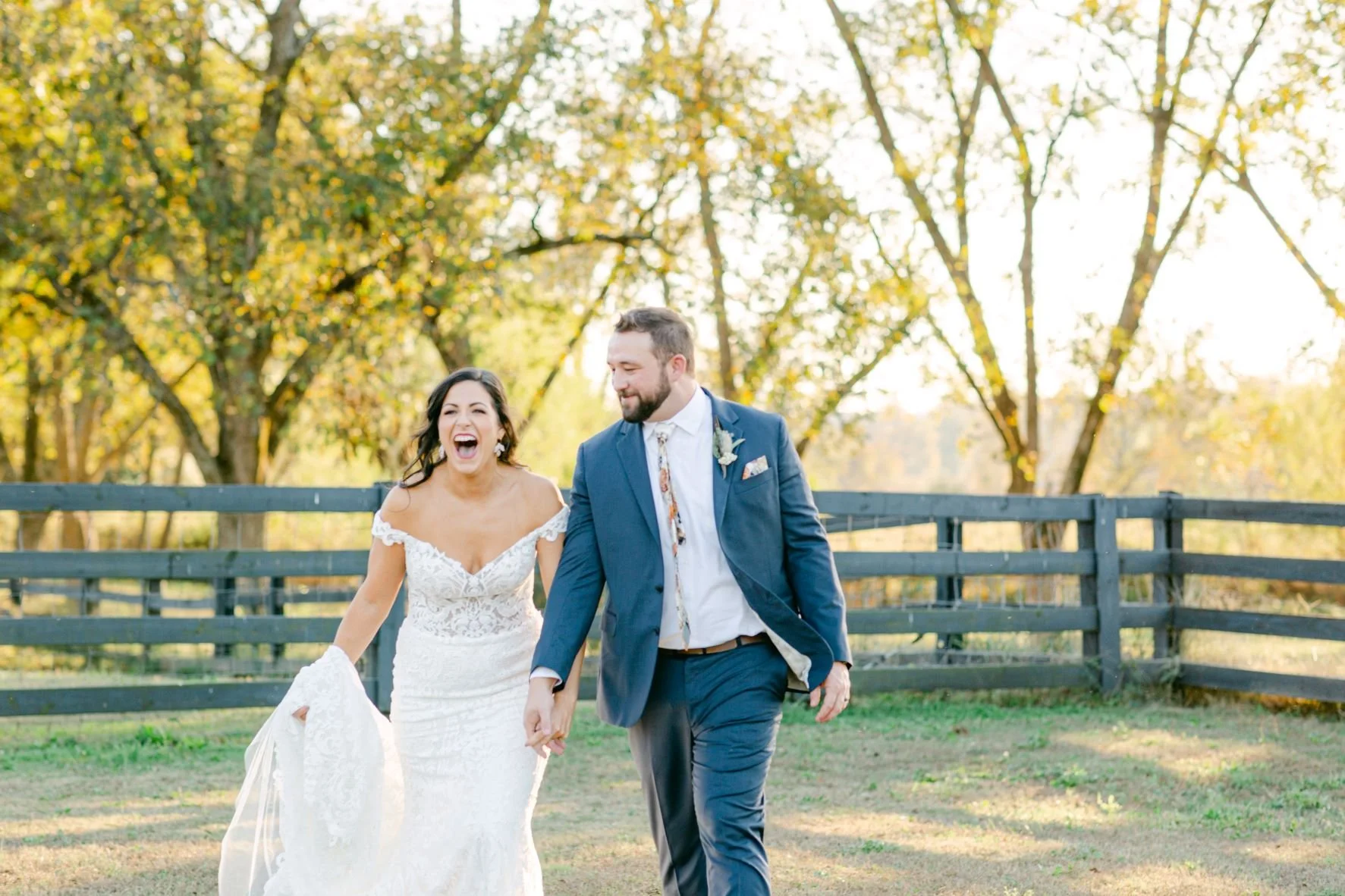 bride-groom-smiling-excited-fall-leaves-on-farm.jpg