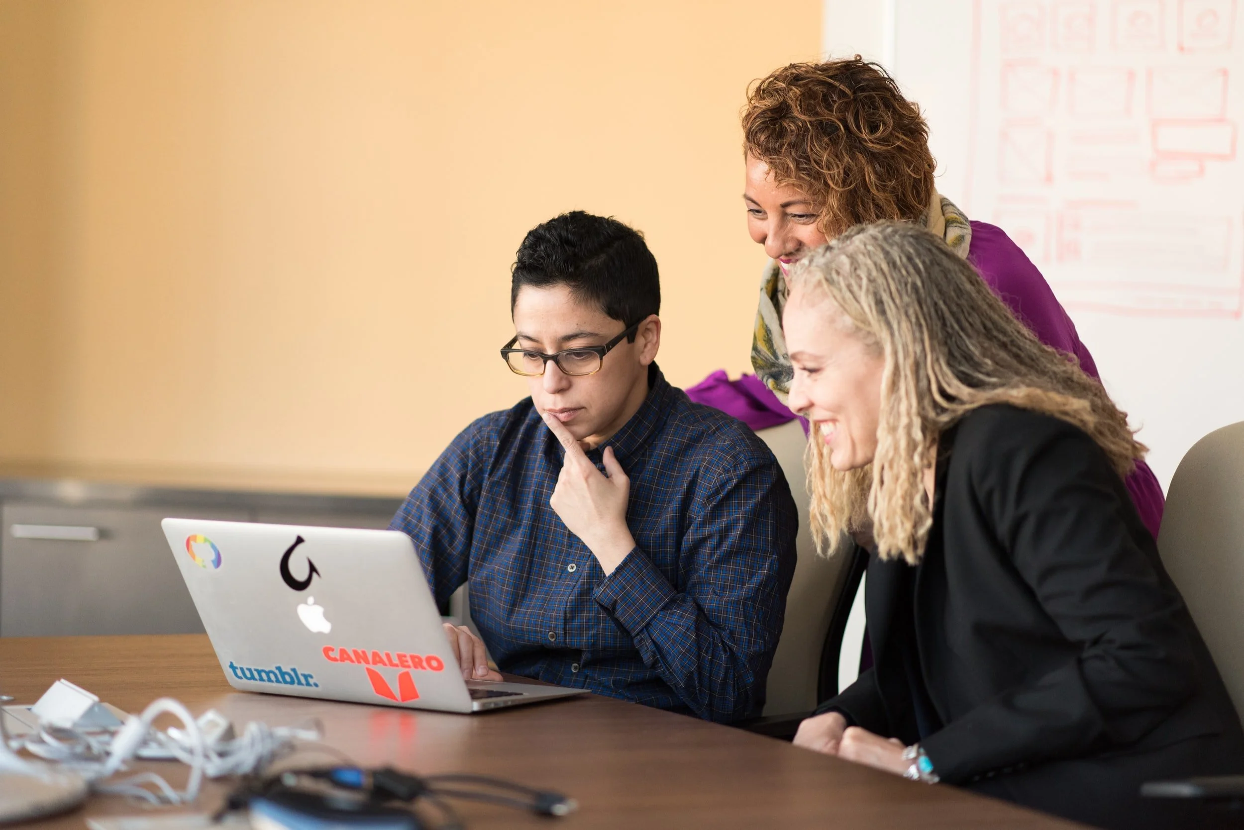 group of women smiling at computer