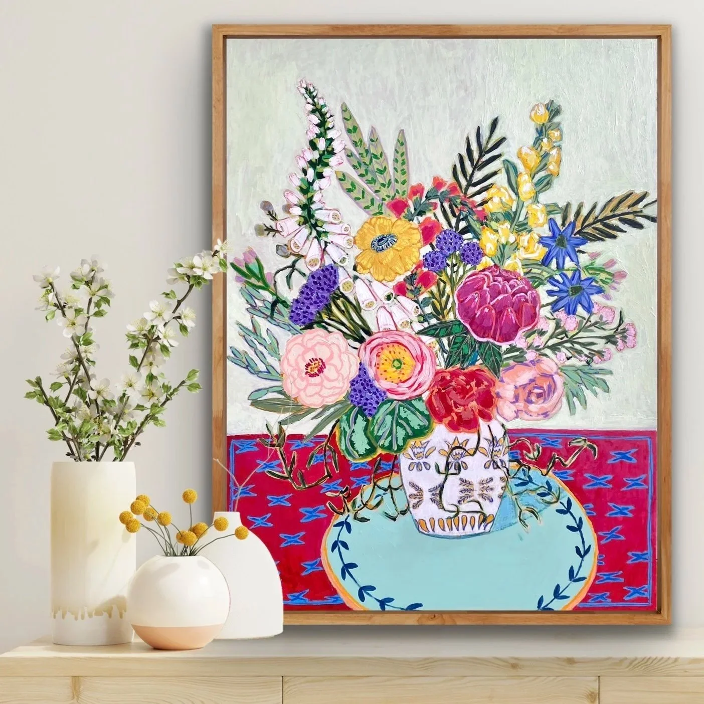 Colorful abstract painting of a bouquet of flowers in a decorative vase on a vibrant tablecloth, with a white background.