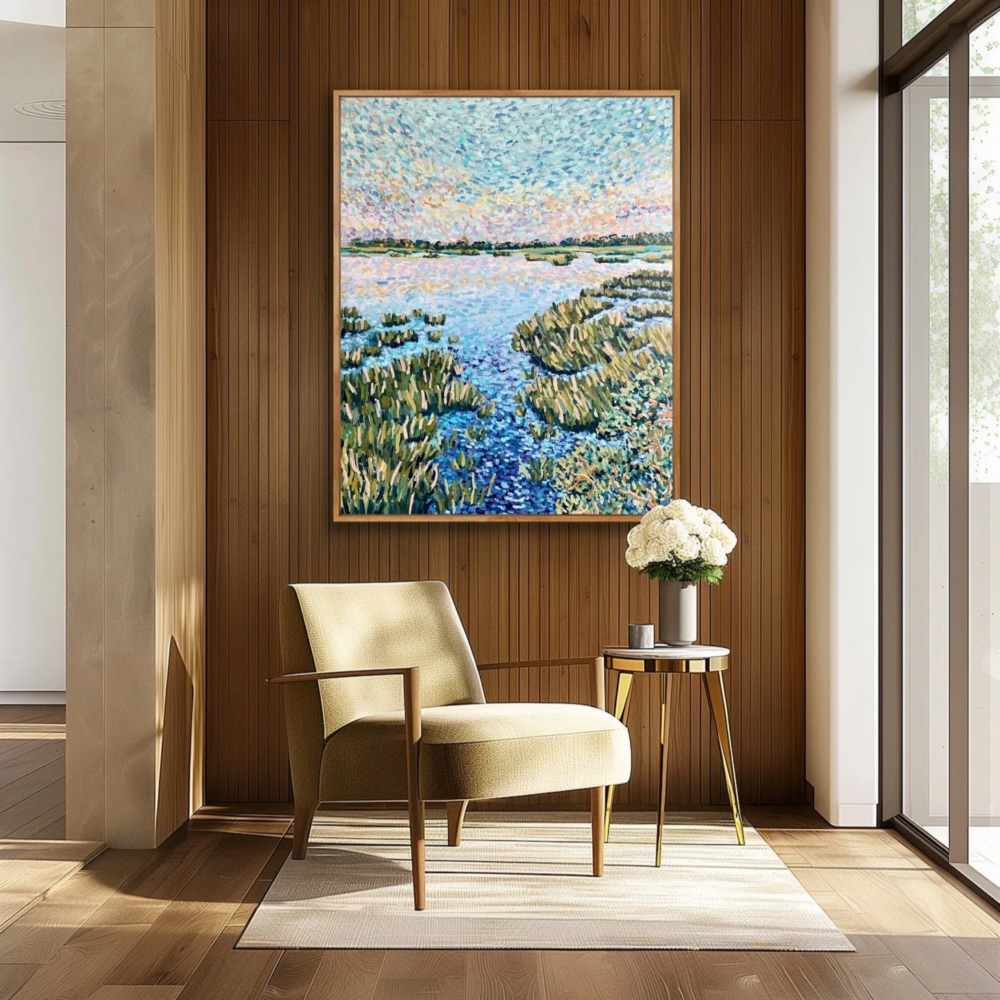 Minimalist living space with a beige armchair, a side table with a white flower vase, and framed landscape painting of a water scene with green vegetation.