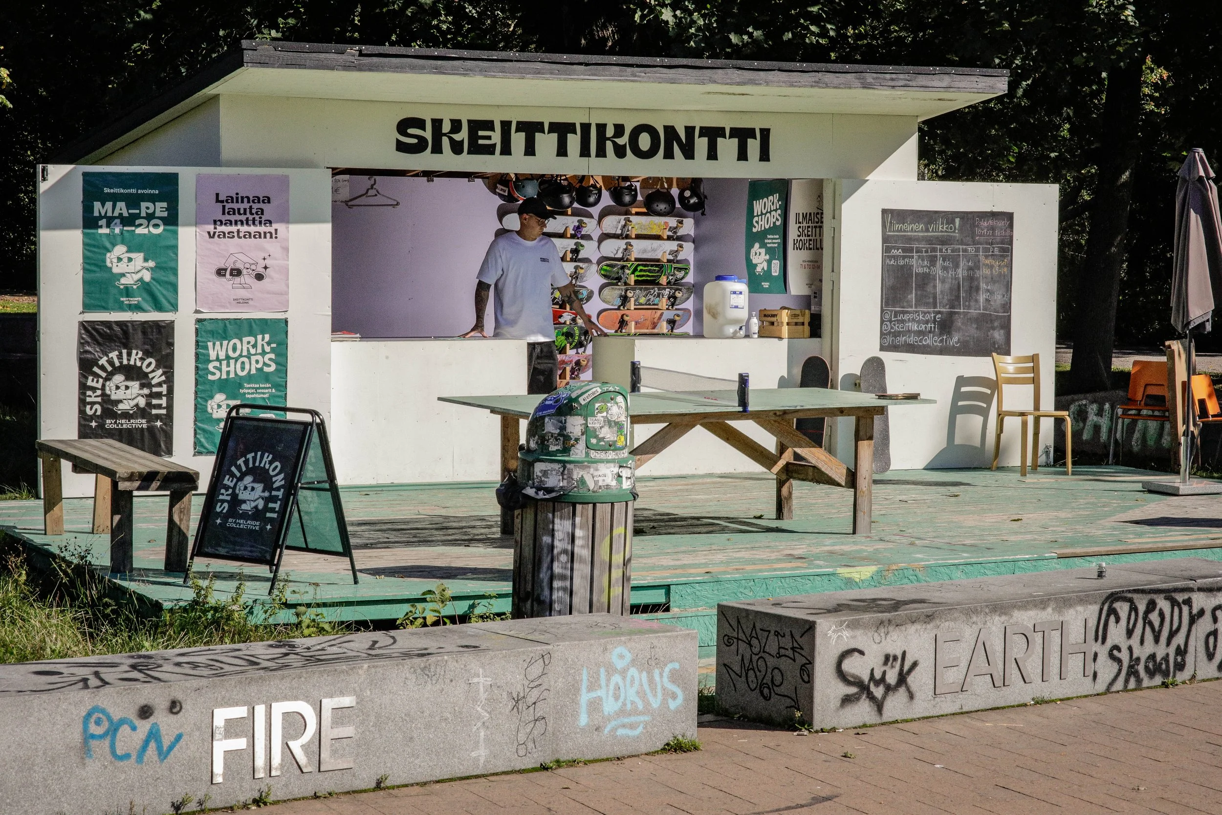 eläintarhan skeittikontilla aikuinen nuoriso-ohjaaja valmiina auttamaan nuorisoa skeittauksen kanssa