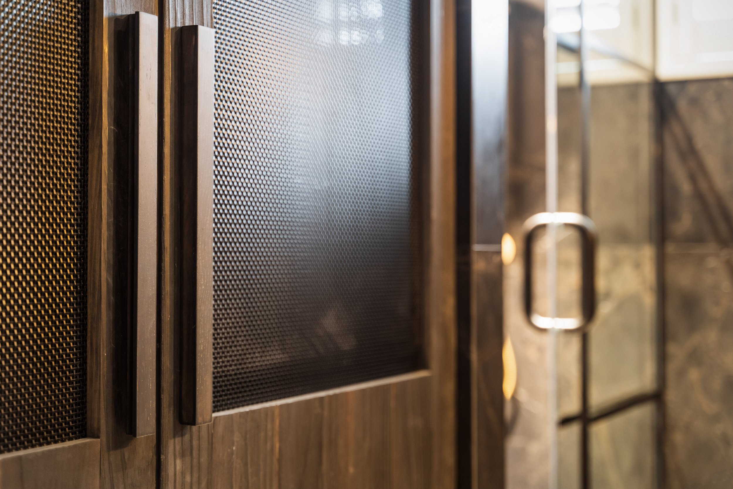 The custom-built shou sugi ban and mesh cabinets cleverly hide a compact yet efficiently designed laundry area, featuring a steamer, a pull-out laundry drawer, and a washer-dryer combination as well as extra shelving - everything you need in a compac