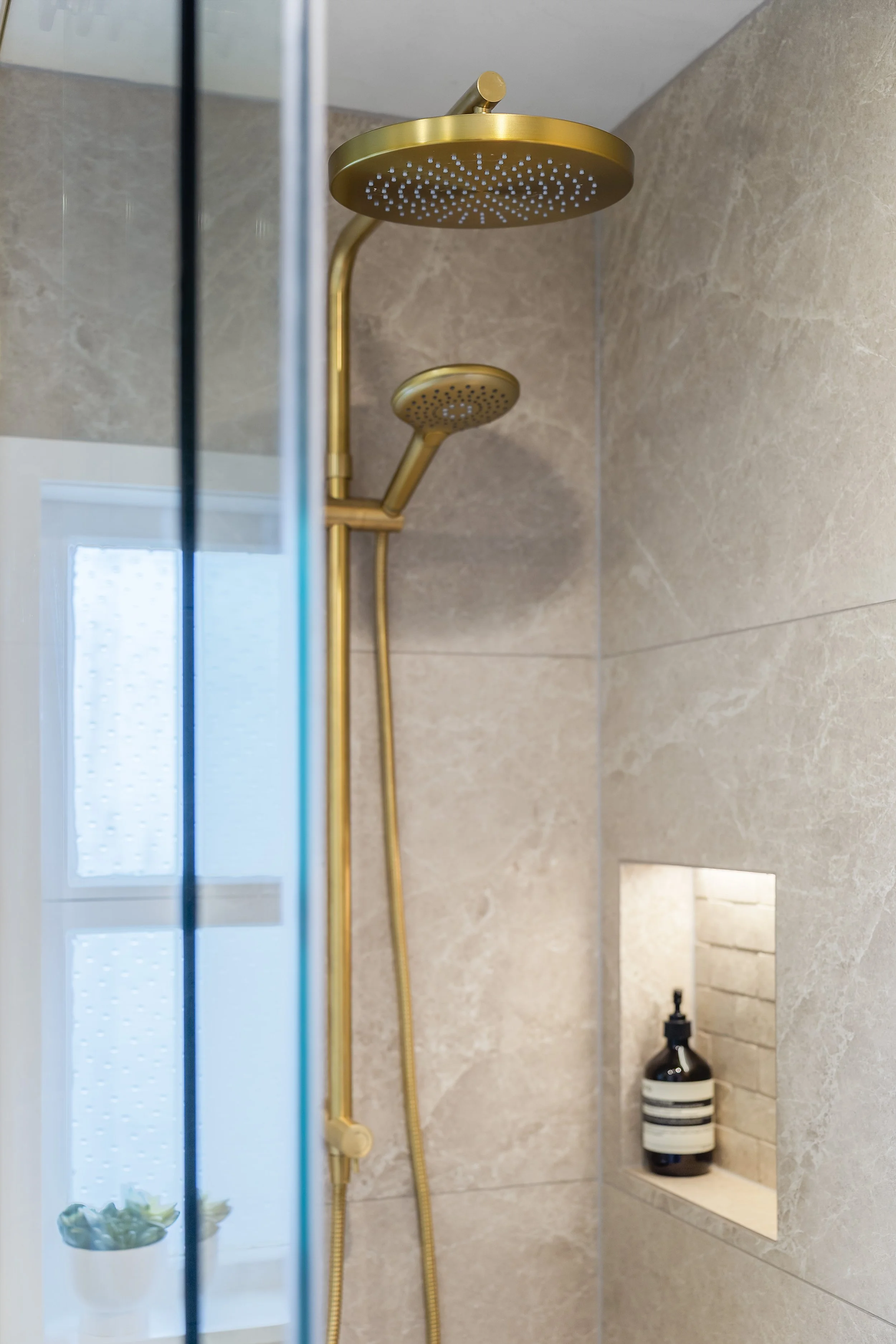 Elevating the daily routine, the brushed brass waterfall shower head offers both luxury and a grand aesthetic.
