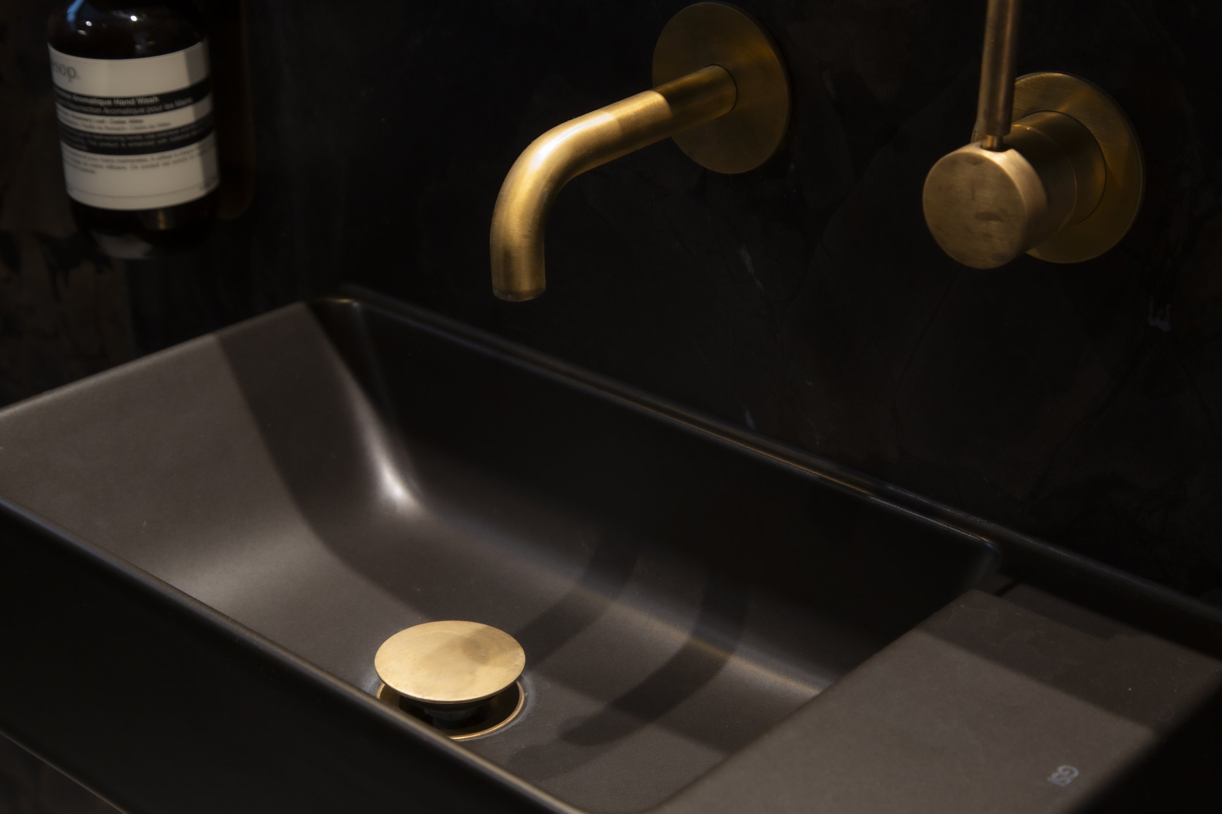 The black vanity basin highlights the stunning aged brass Progetto tapware.