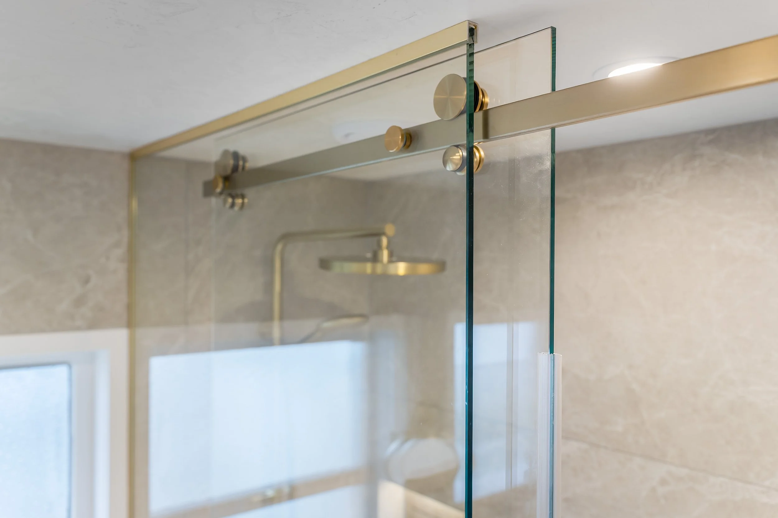 The floor-to-ceiling custom brushed brass sliding shower door is a beautiful solution that keeps steam contained and the rest of the bathroom clear. This smart practicality is mirrored by the waxed fresco ceiling, which maintains its stunning look wh
