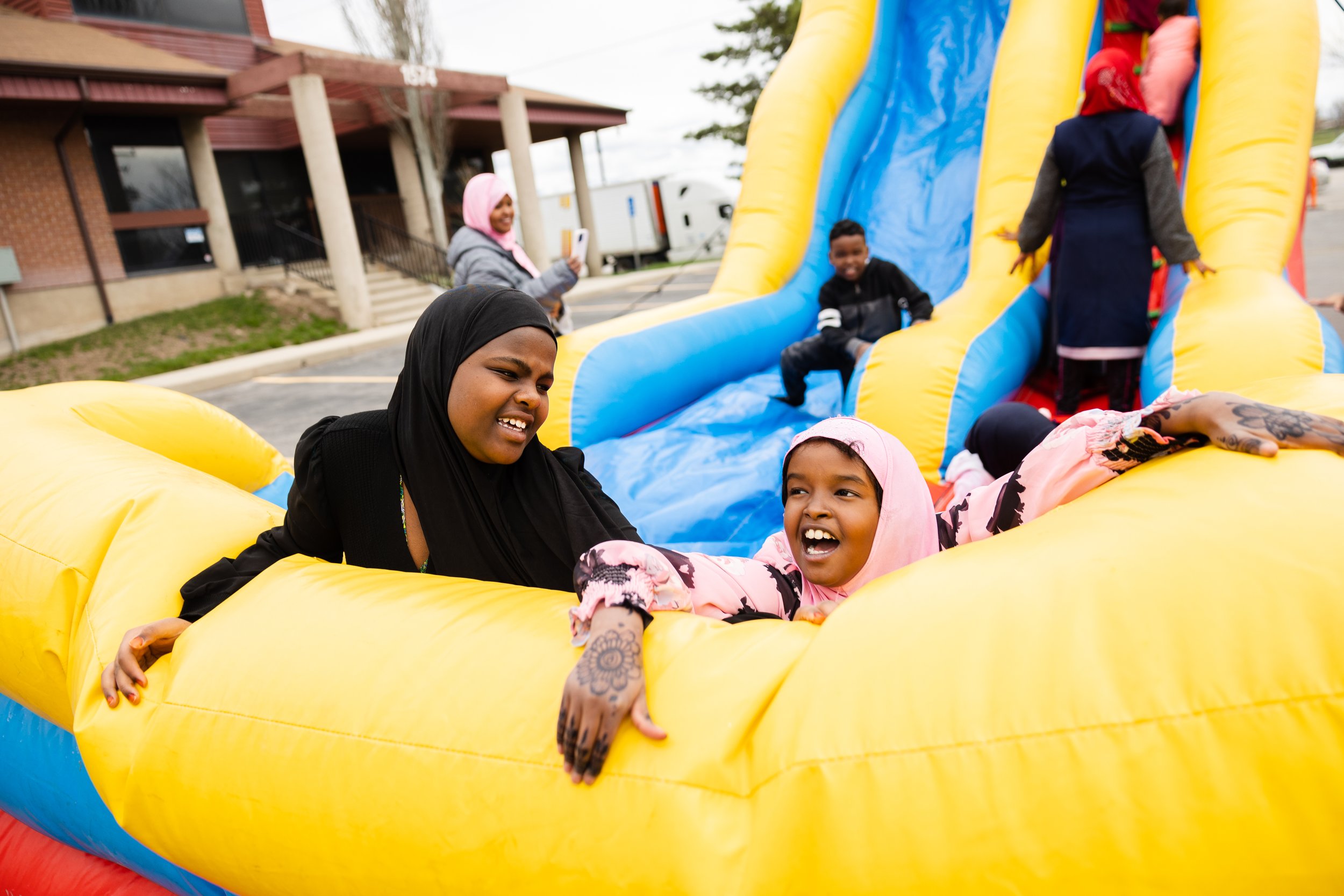  Filsan Salad, 10 years old, right, laughs while playing in an inflatable slide during the Eid al-Fitr celebration at Hartland Partnership Center in Salt Lake City on April 22, 2023. 