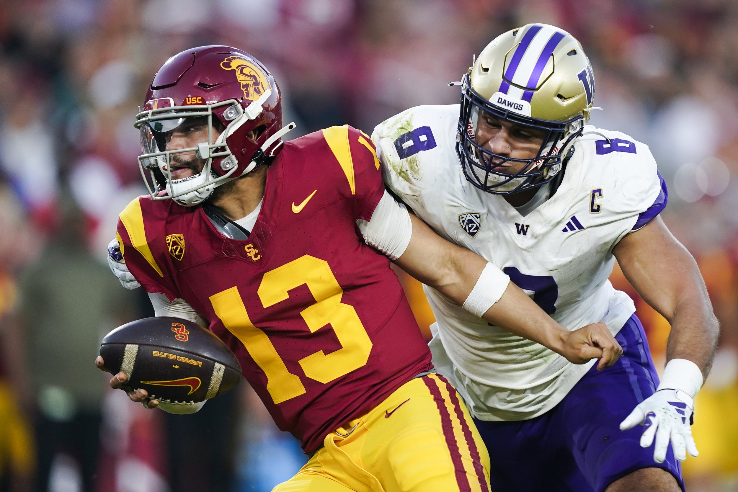  Southern California quarterback Caleb Williams, left, gets away from Washington defensive end Bralen Trice during the first half of an NCAA college football game Saturday, Nov. 4, 2023, in Los Angeles. 