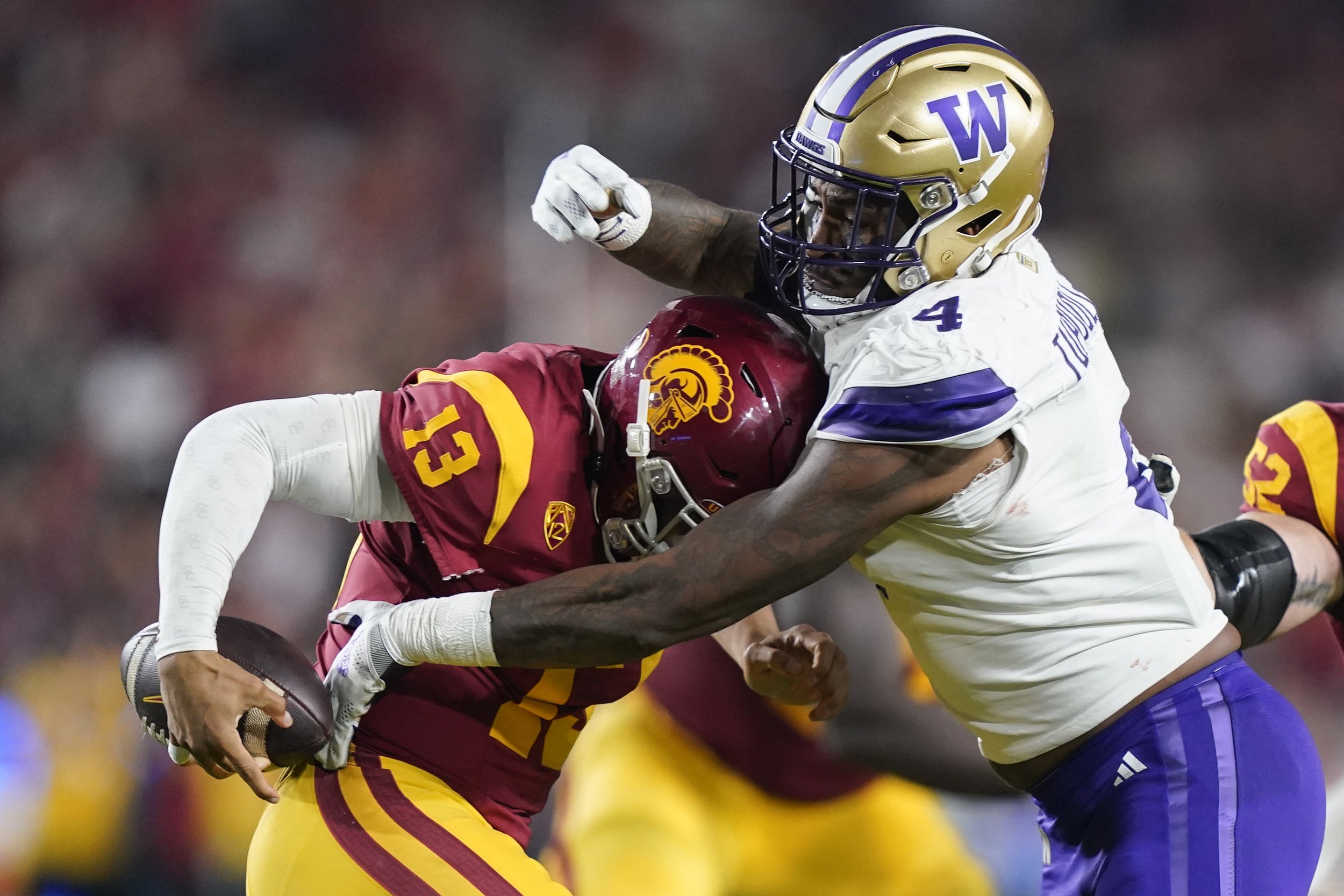  Washington defensive end Zion Tupuola-Fetui, right, forces a fumble by Southern California quarterback Caleb Williams during the first half of an NCAA college football game Saturday, Nov. 4, 2023, in Los Angeles. 