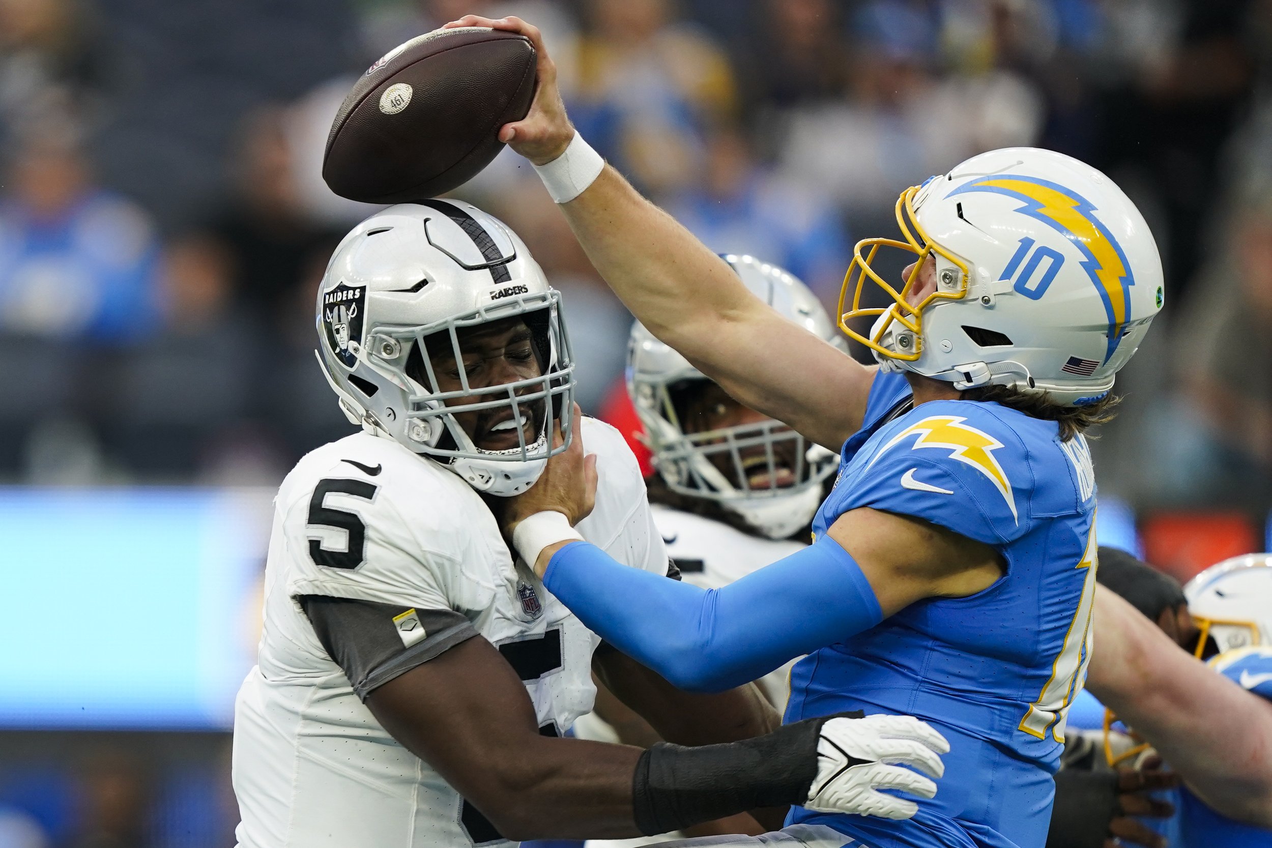  Los Angeles Chargers quarterback Justin Herbert (10) throws under pressure from Las Vegas Raiders linebacker Divine Deablo during the first half of an NFL football game Sunday, Oct. 1, 2023, in Inglewood, Calif. 