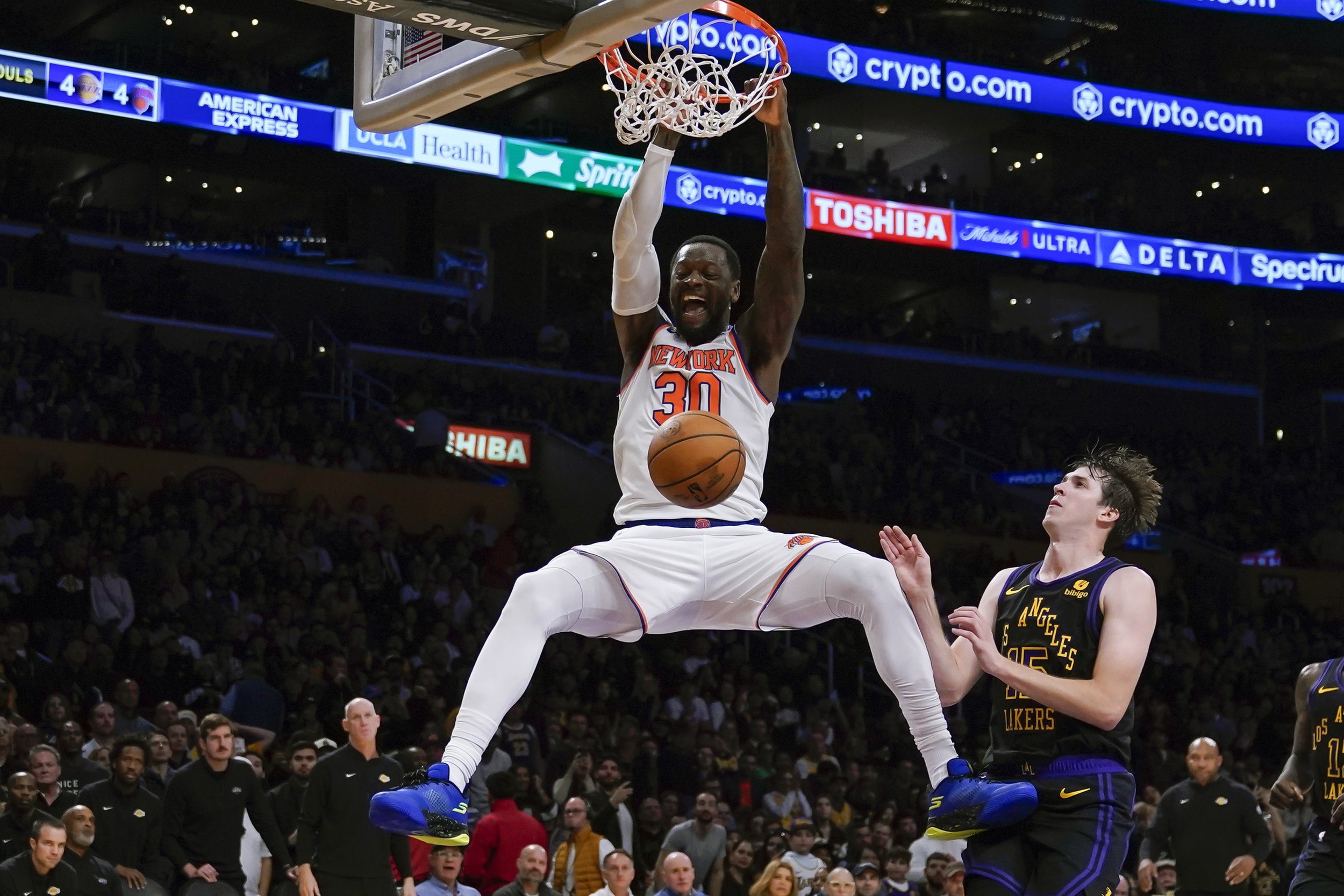  New York Knicks forward Julius Randle (30) dunks the ball against Los Angeles Lakers guard Austin Reaves (15) during the second half of an NBA basketball game, Monday, Dec. 18, 2023, in Los Angeles. 