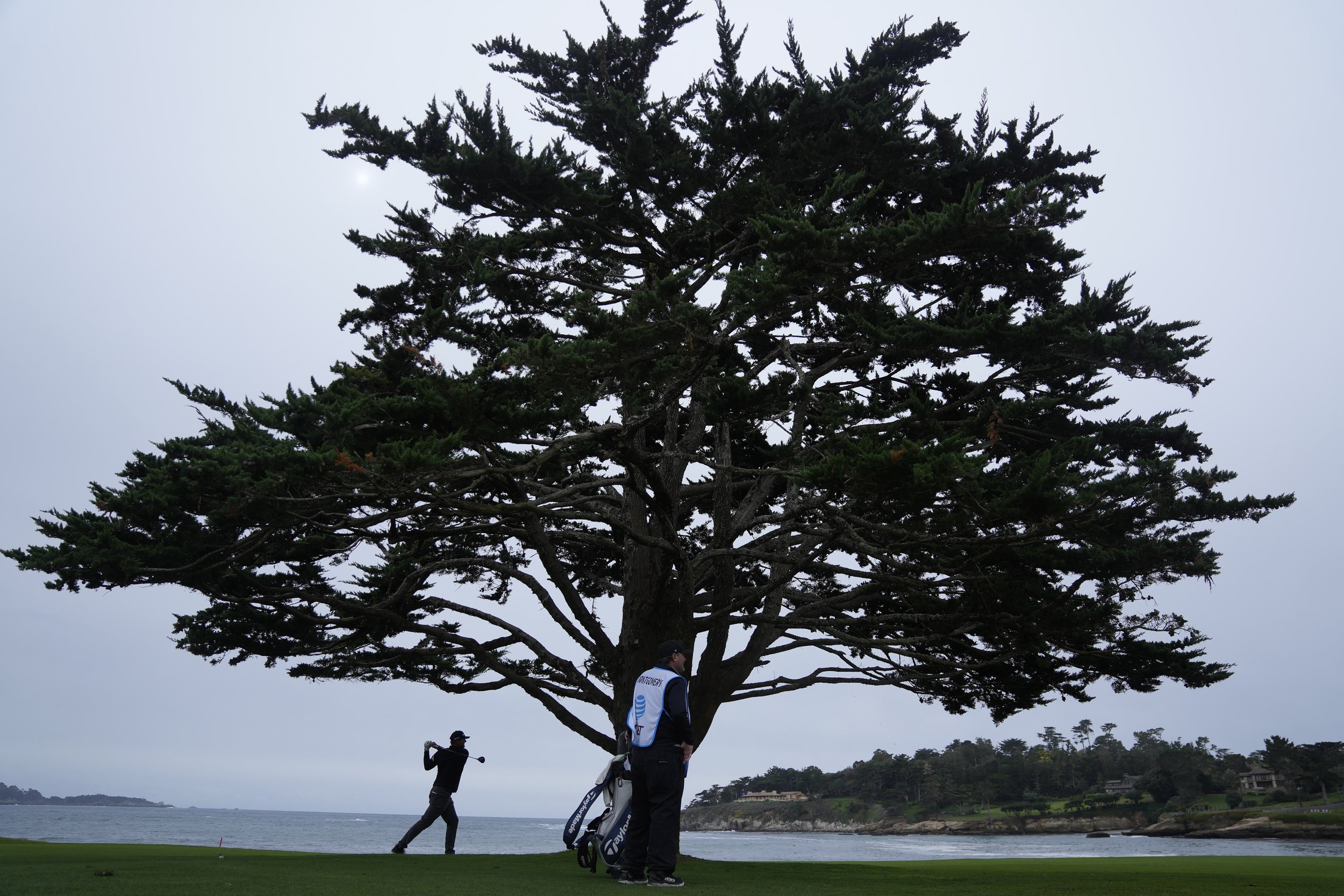  Taylor Montgomery, left, hits from the 18th fairway at Pebble Beach Golf Links during the third round of the AT&amp;T Pebble Beach National Pro-Am golf tournament in Pebble Beach, Calif., Saturday, Feb. 3, 2024. 