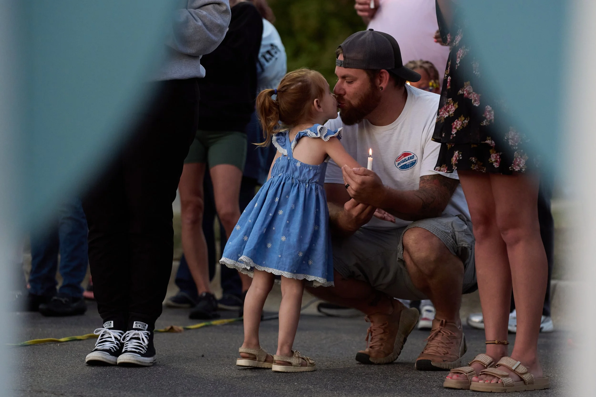  Devon Lamb, of Durand, kisses his daughter Lux during a vigil held at the Henry Ford Genesys Regional Hospital for the Sunday morning shooting at The Church of Jesus Christ of Latter-day Saints in Grand Blanc Township, Mich., Tuesday, Sept. 30, 2025