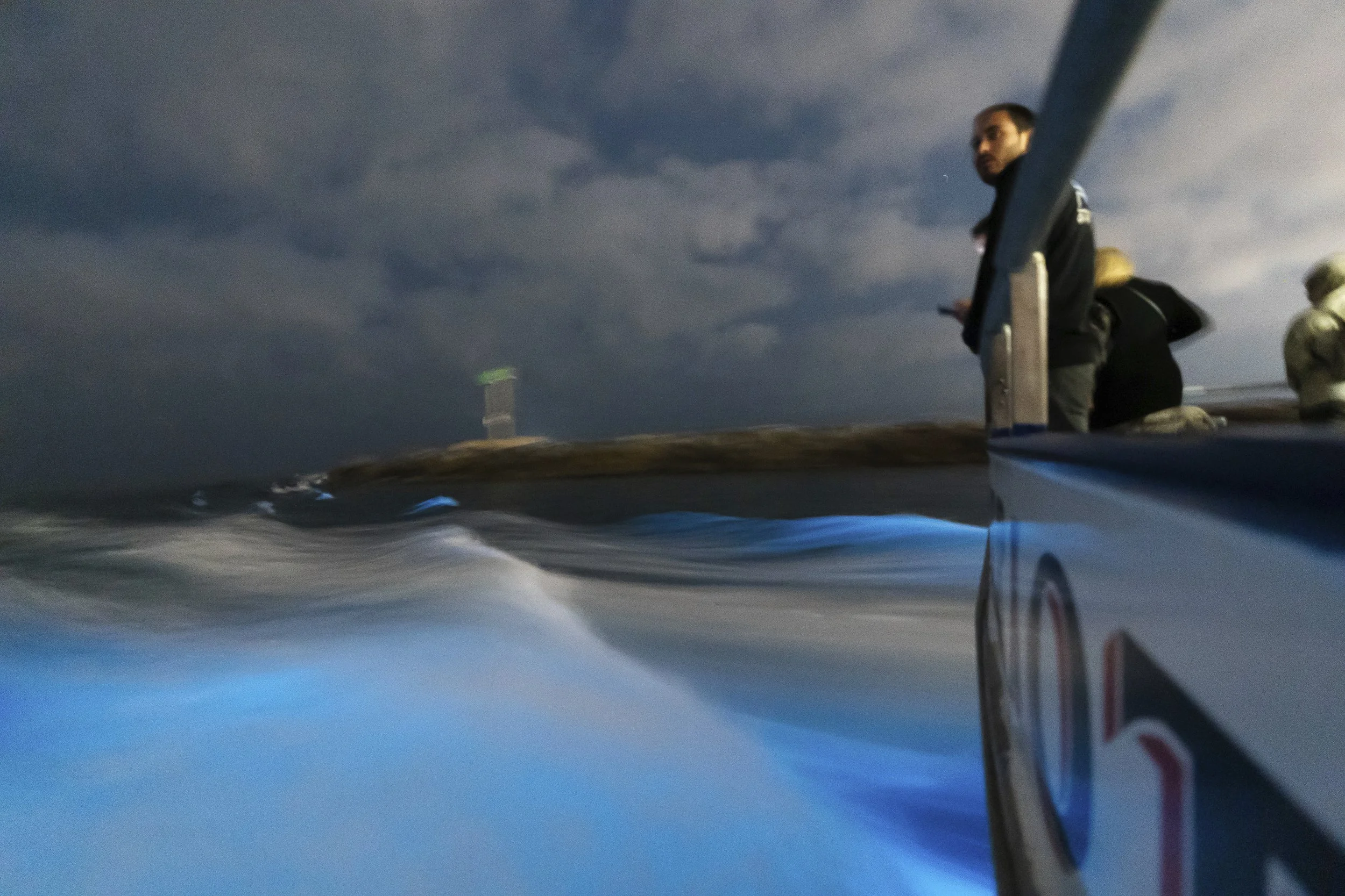  A man looks over the railing as waves glow with blue bioluminescence from microscopic organisms called lingulodinium polyedra, Wednesday, Sept. 13, 2023, in Newport Beach, Calif. 