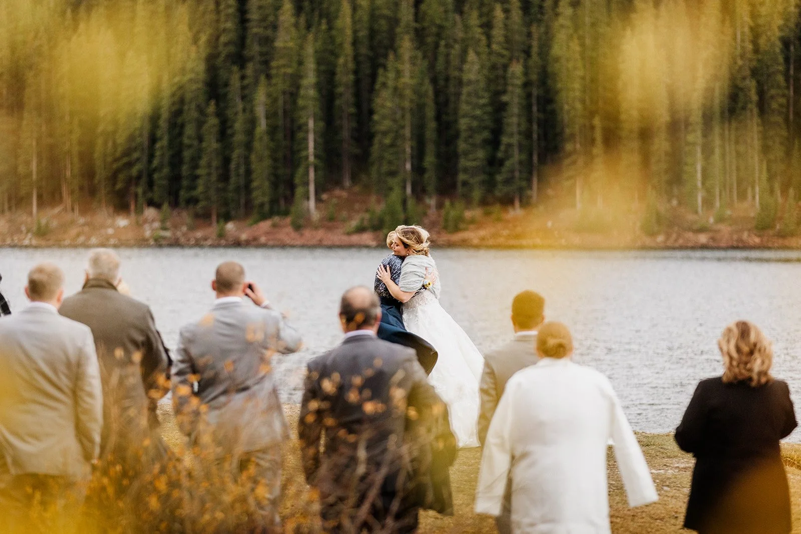 A mother and daughter embrace during a first dance at a Colorado lake