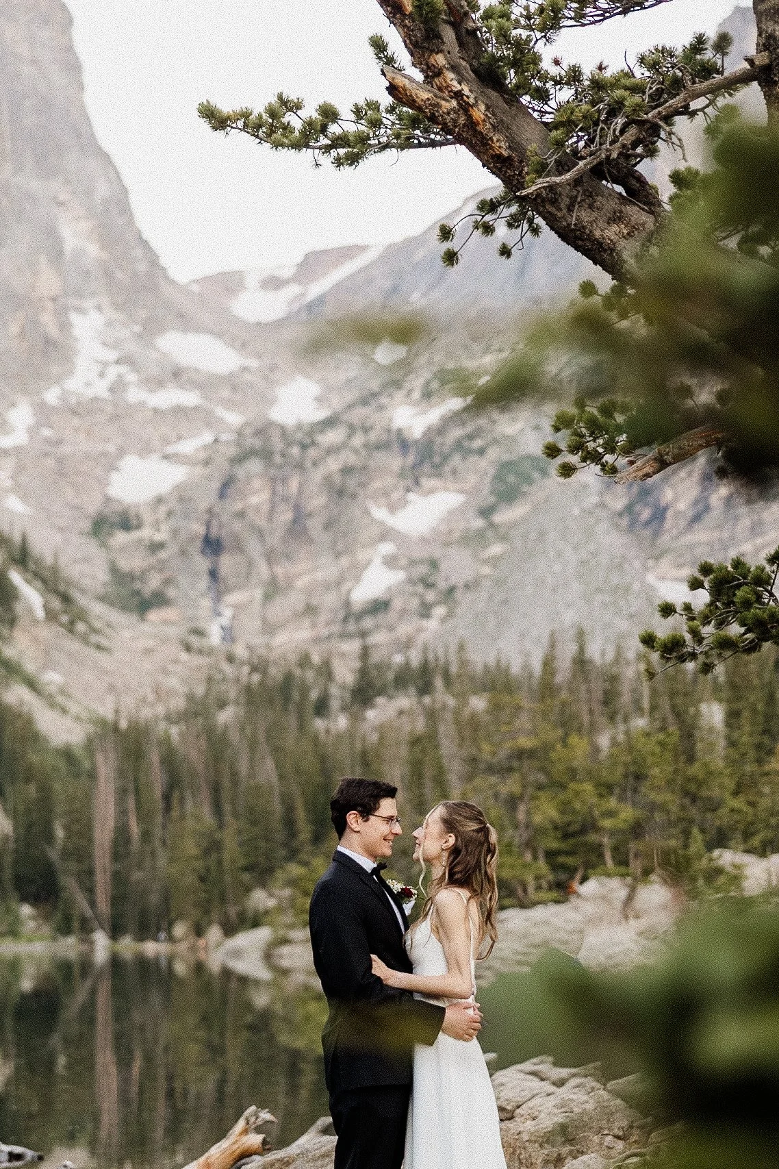 The same photo edited, with the fisherman removed so only the couple and the mountain lake remain