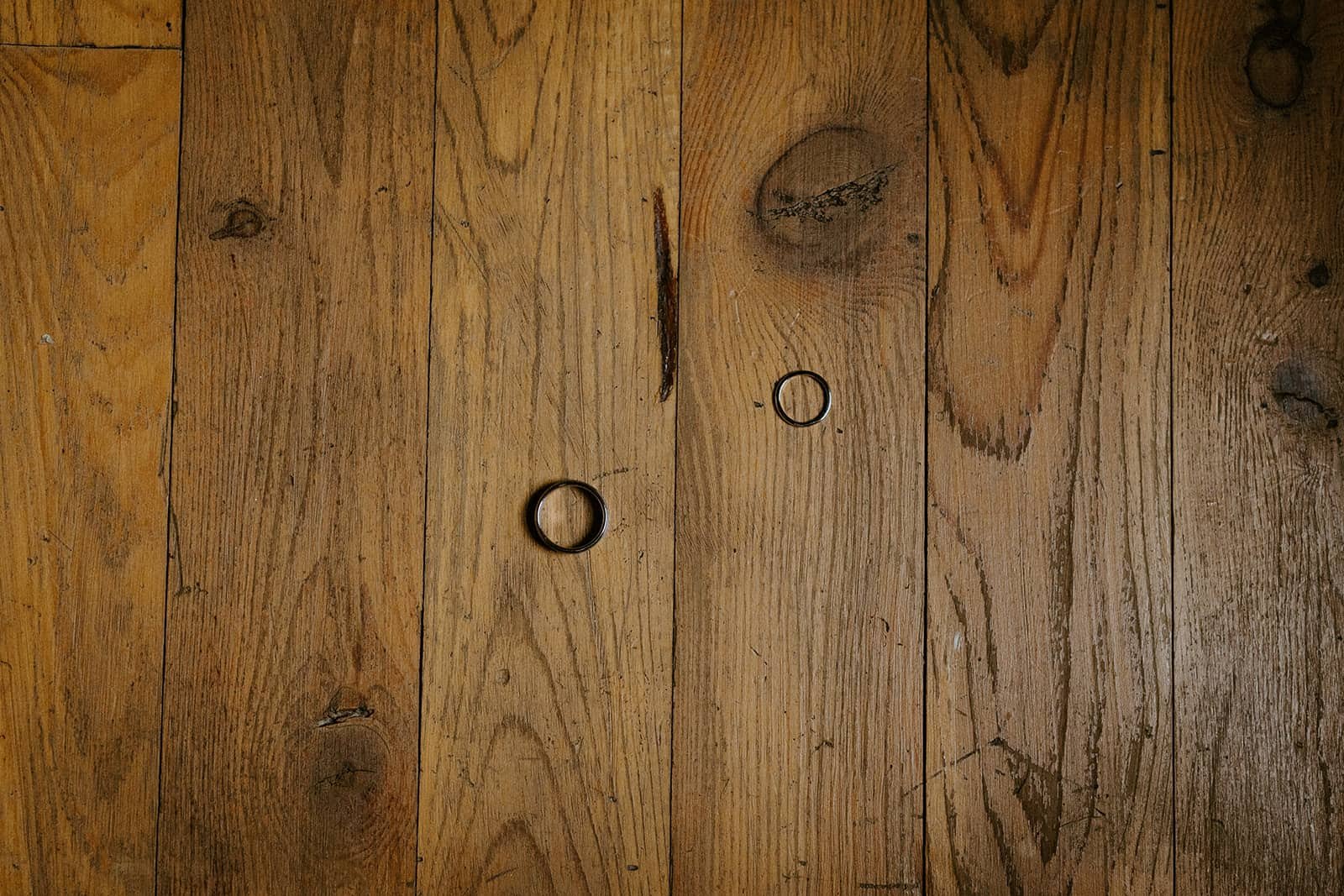 two rings sit on a wood floor