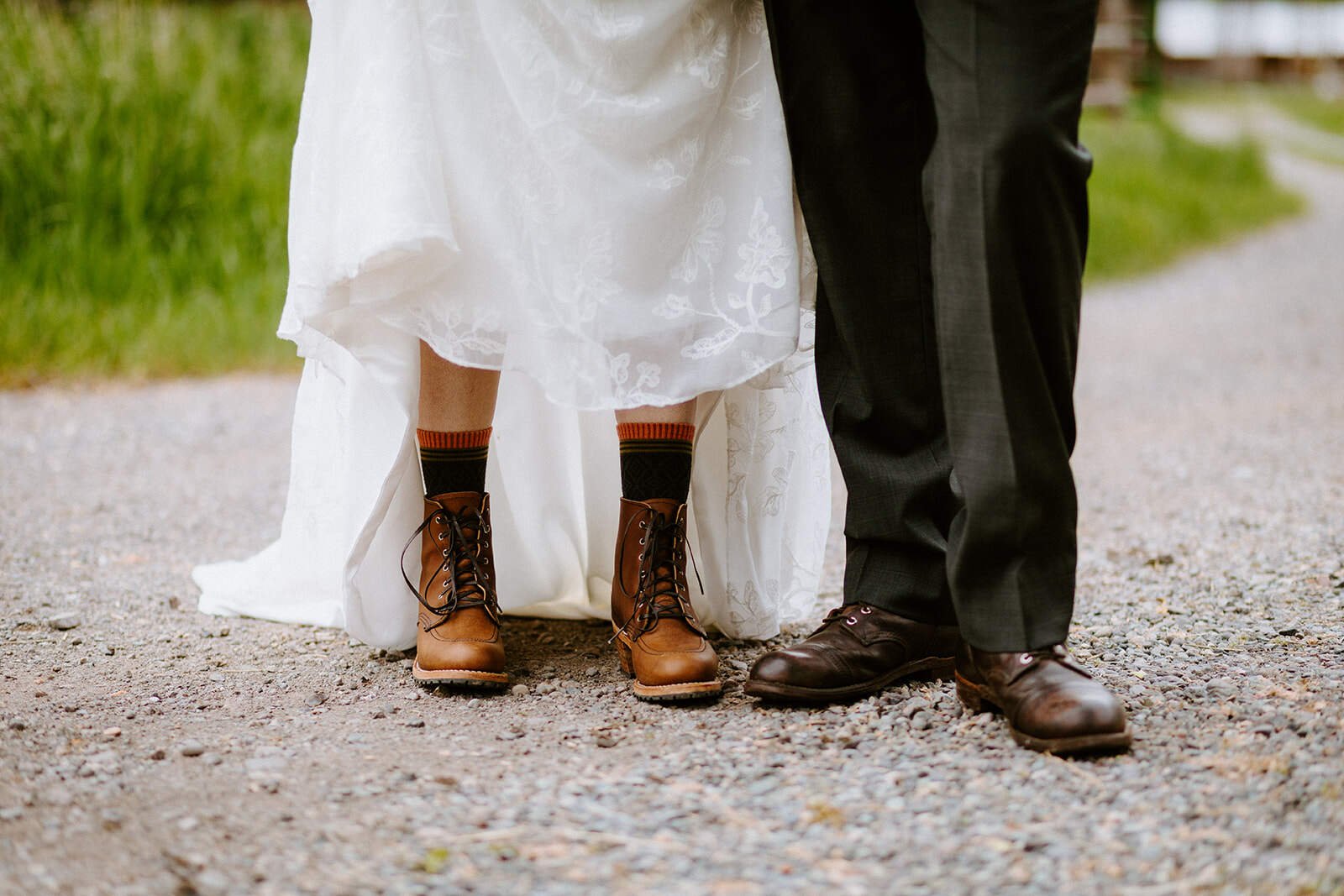 A couple stands side by side in their Redwing boots on their wedding day