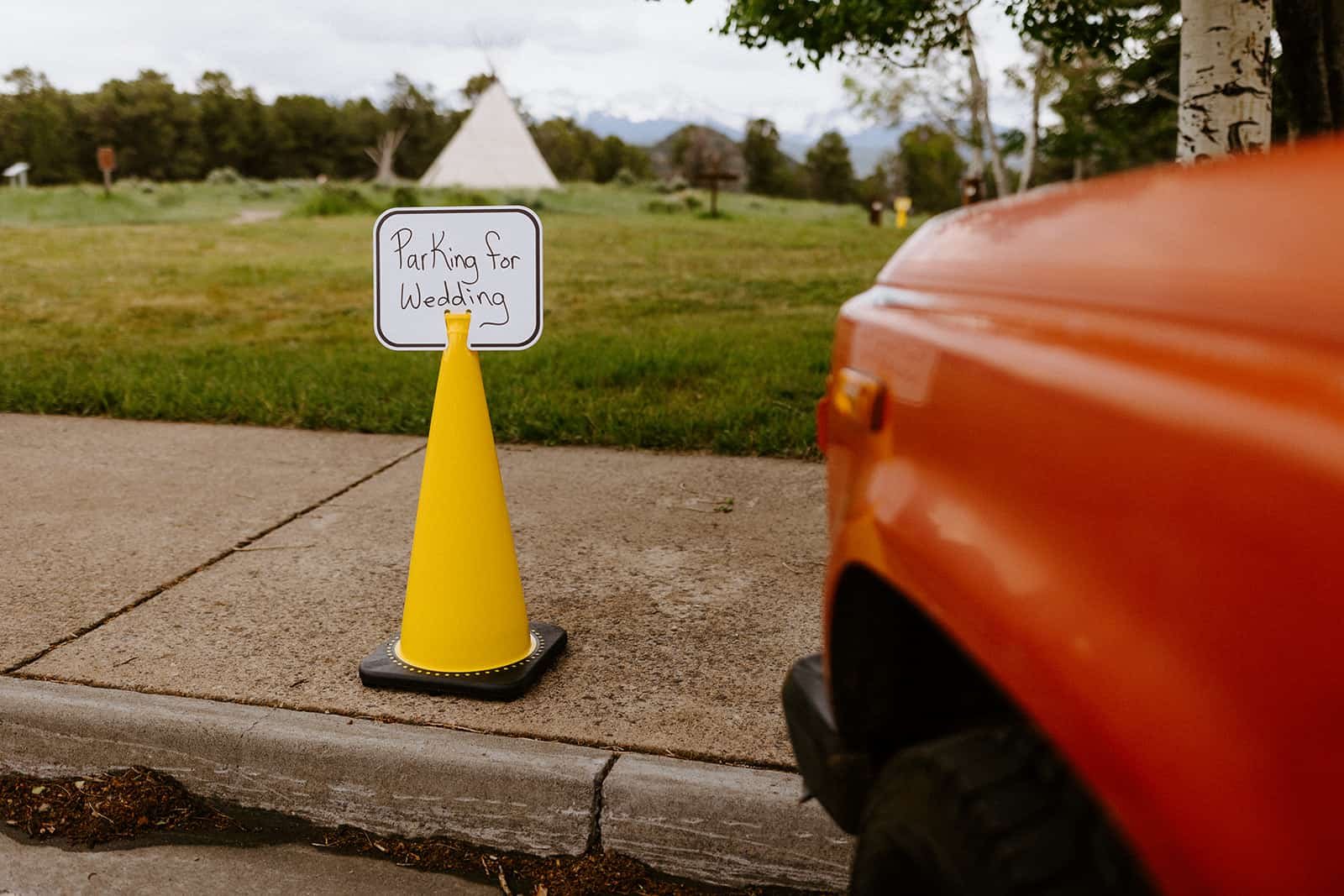 A yellow cone holds a sign "Parking for Wedding" at Ridgway State Park