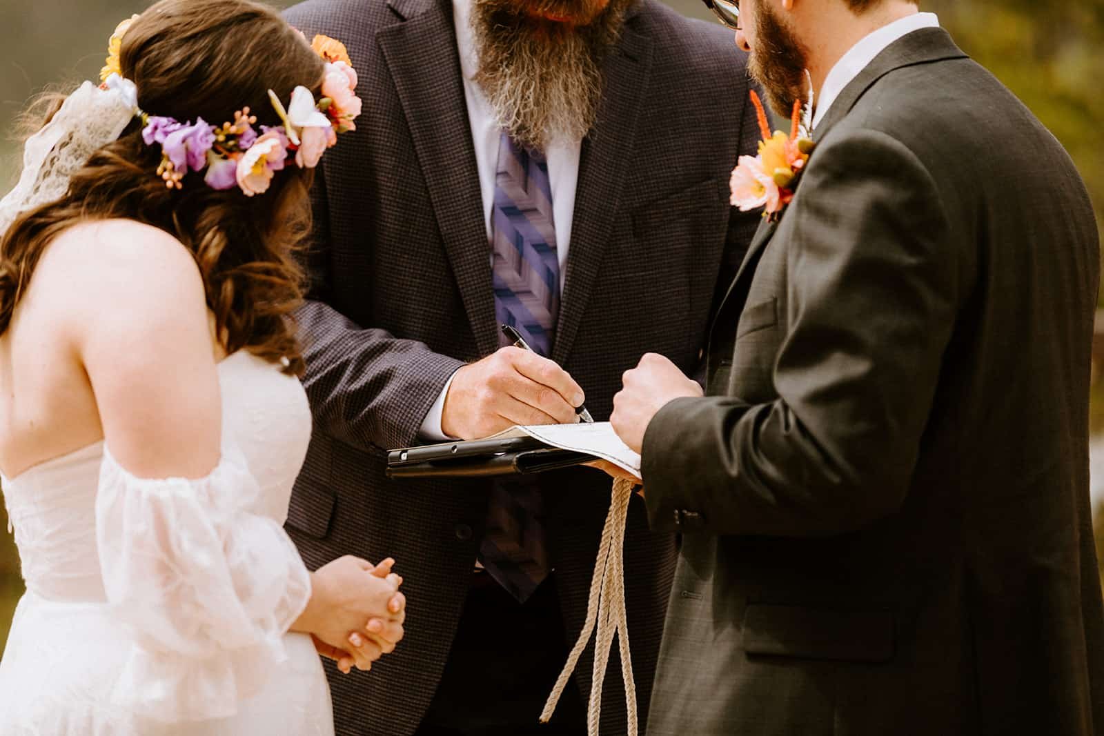 A couple signs their marriage license with their officiant in Colorado