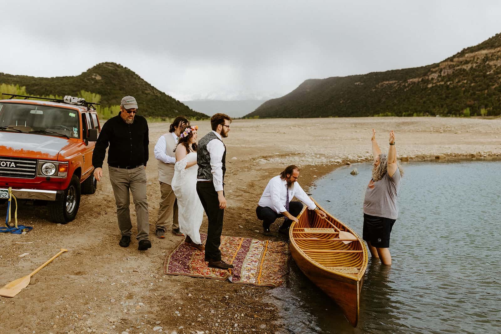 A family celebrates a couple making it safely back to shore in their wood canoe