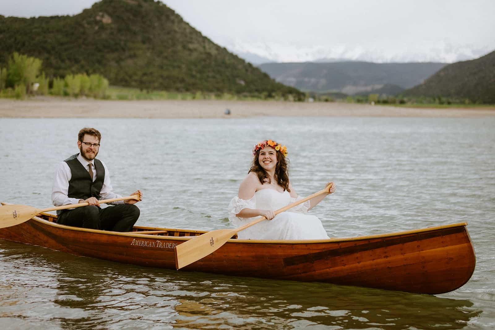A couple in a wedding dress and suit paddle around Ridgway State Park