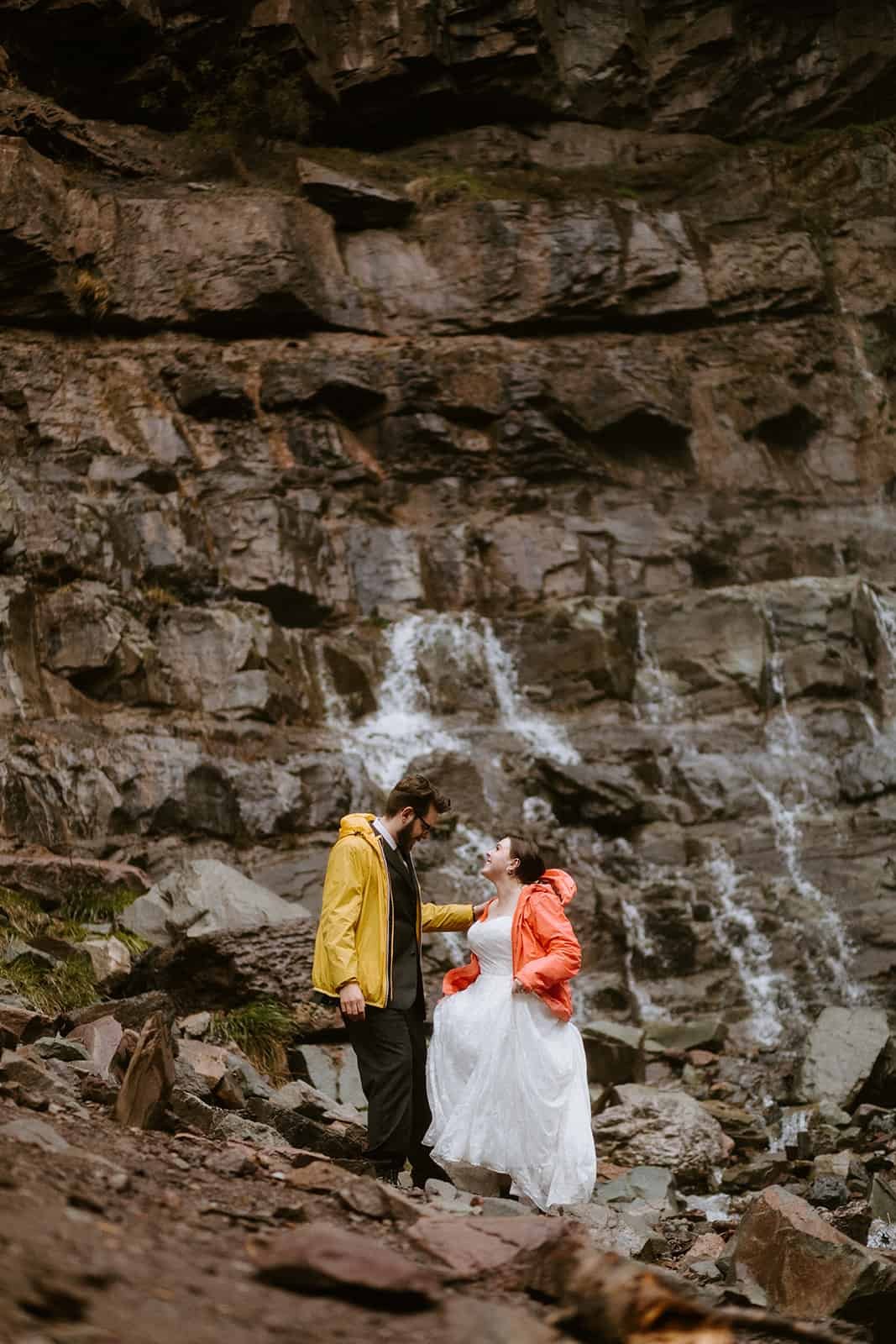A couple turned around looking at a waterfall in Colorado
