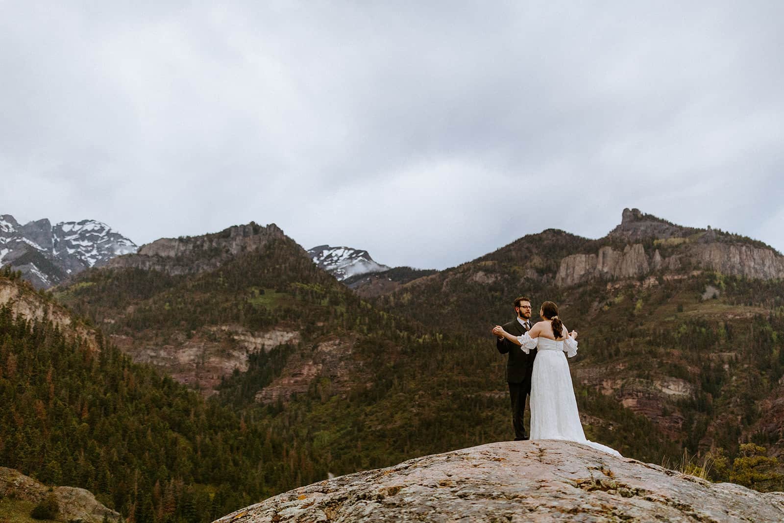 A couple dances in front of the wet San Juan mountains