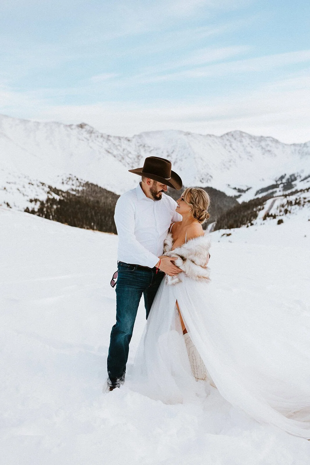 Couple in wedding attire holding hands in the snow at Loveland Pass, a stunning Colorado elopement location