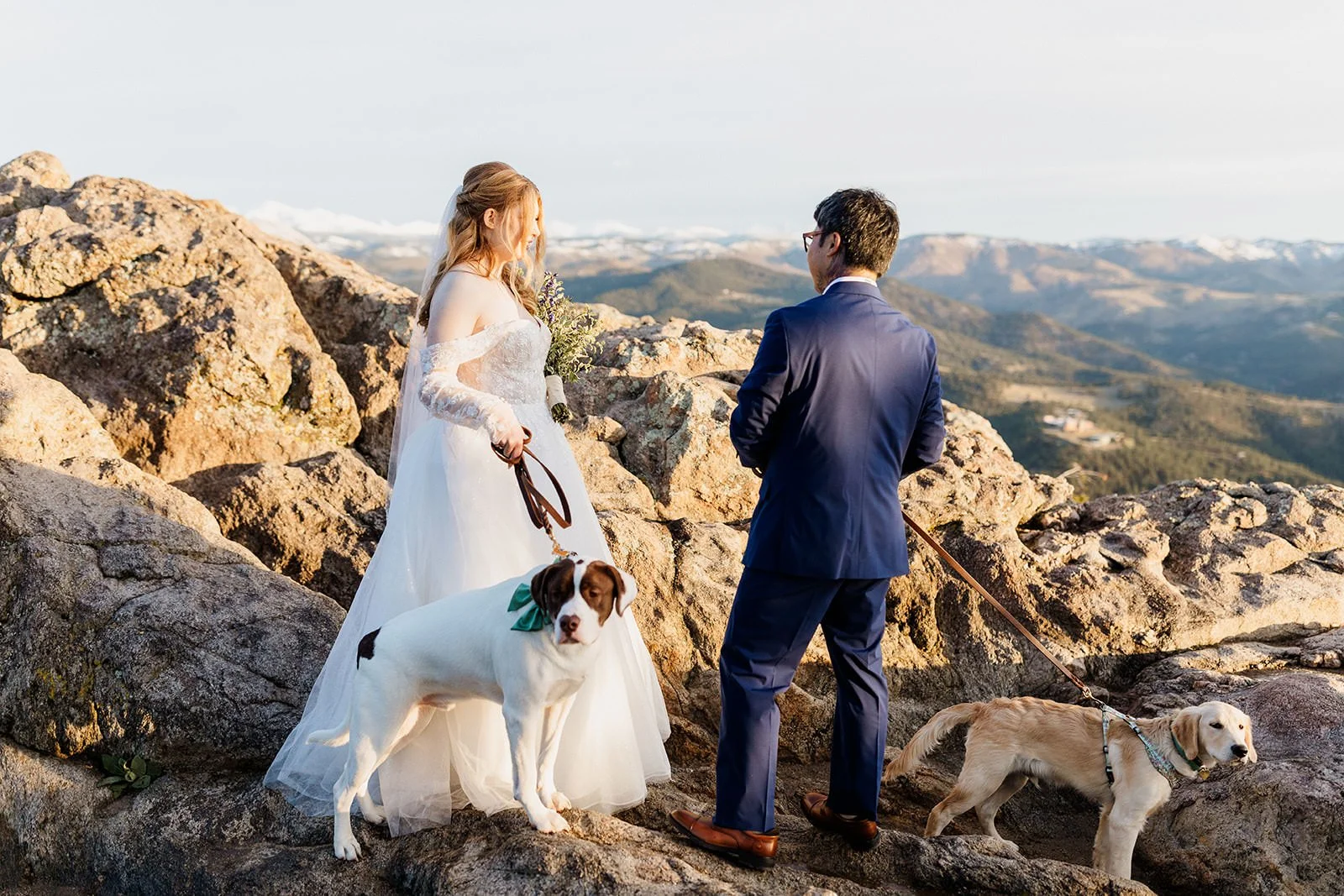 Couple standing on the rocks at Lost Gulch Overlook with their two dogs on leashes