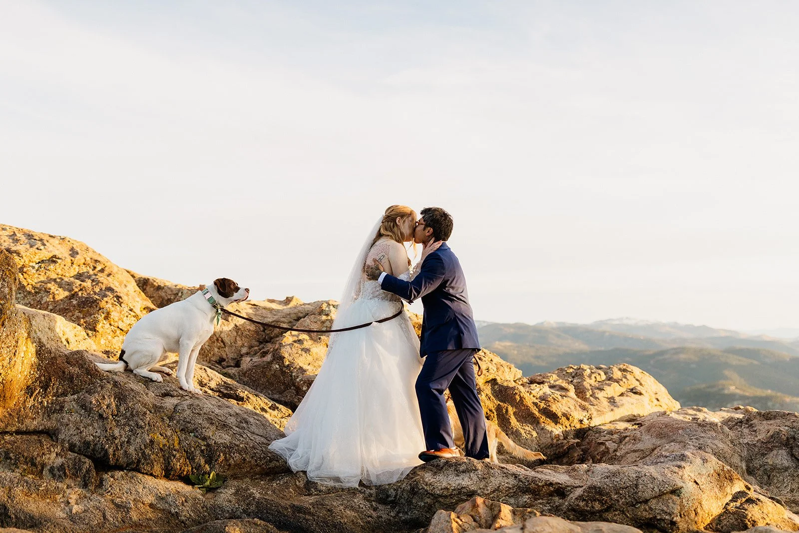 First kiss on the rocks at Lost Gulch Overlook with their dog sitting beside them