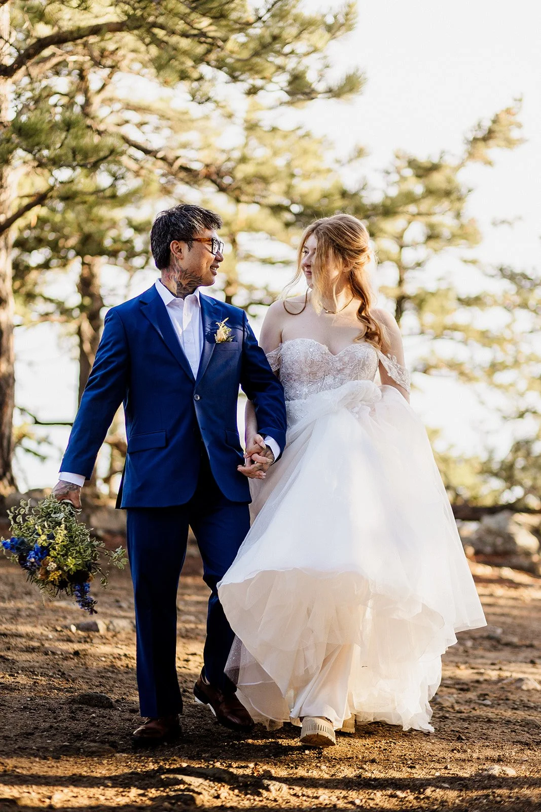 Couple walking toward the camera holding hands and smiling at each other