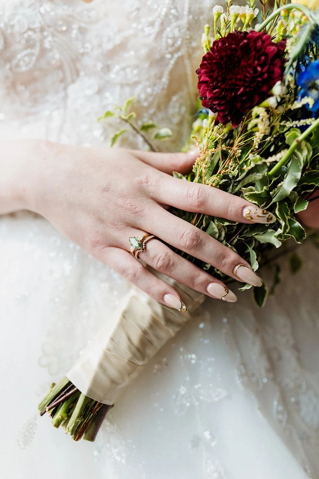 Close up of the bride's hand and engagement ring on her bouquet