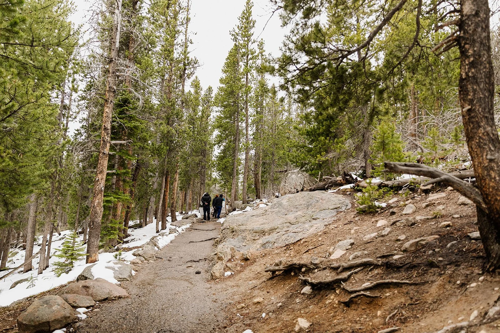 Two hikers on the snowy trail to Dream Lake in Rocky Mountain National Park