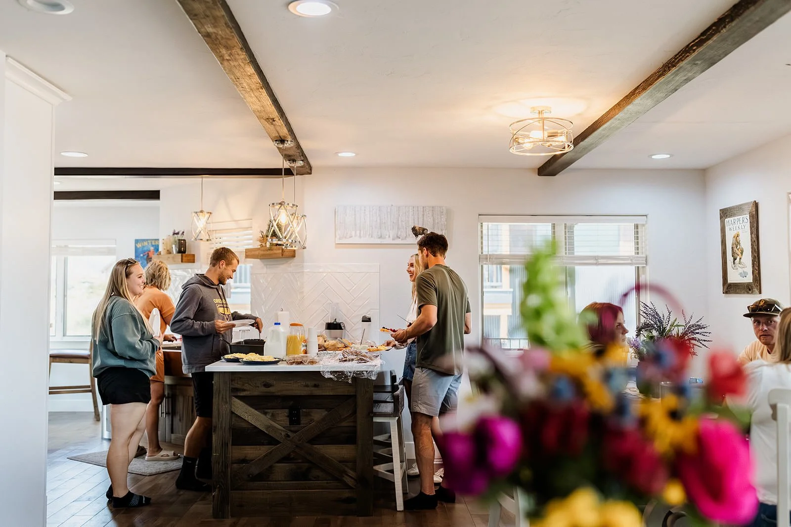 A family and loved ones gather around an AirBNB kitchen after an intimate sunrise wedding in Crested Butte