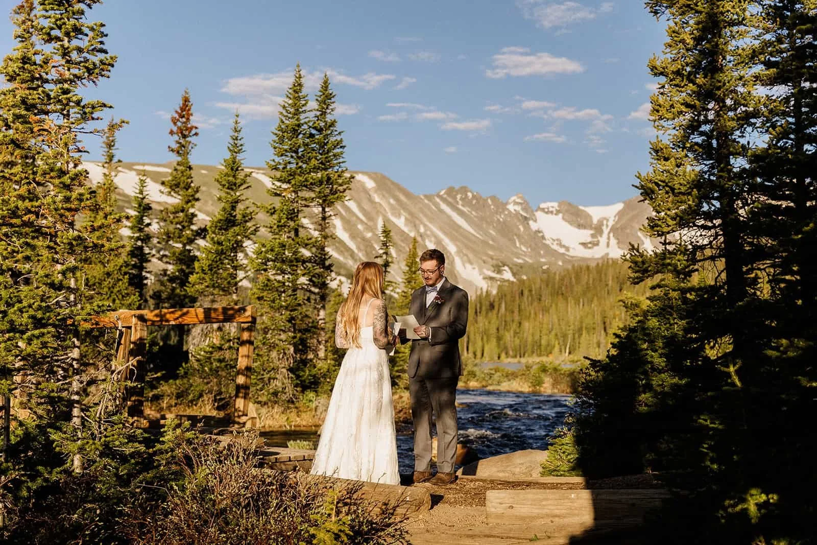 A bride and groom read vows at Long Lake