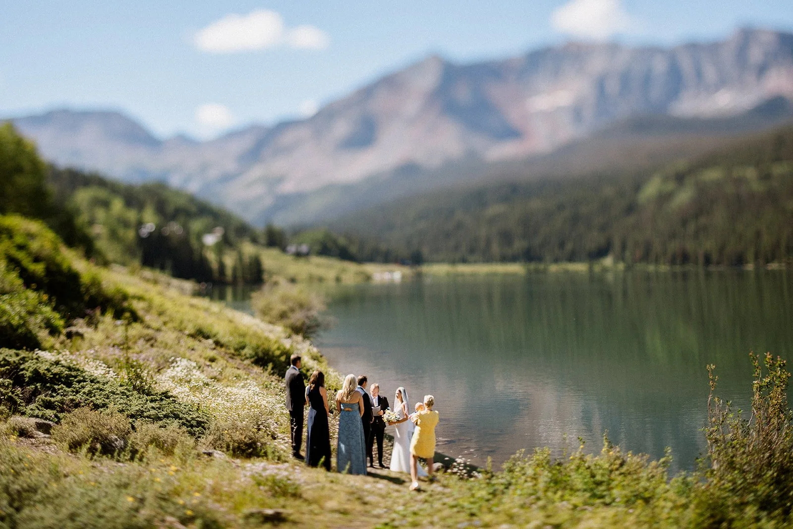A bride and groom get married with their loved ones surrounding them at a Colorado alpine lake