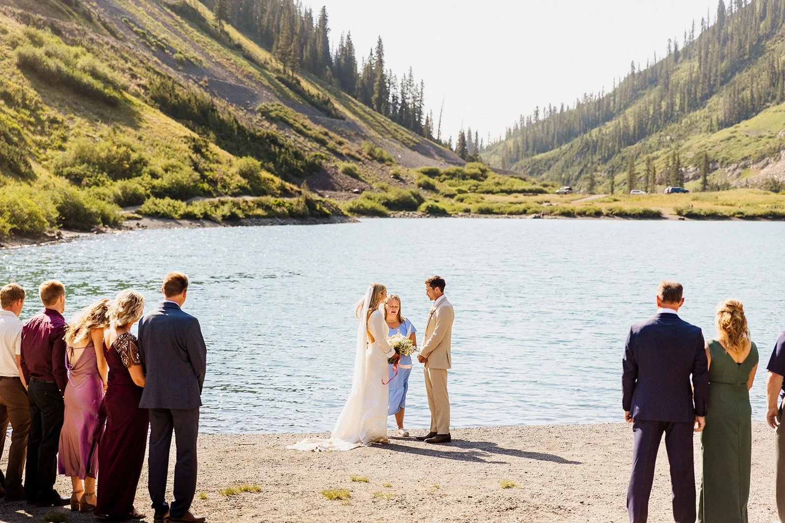 Intimate wedding ceremony at an alpine lake in Crested Butte with family gathered around