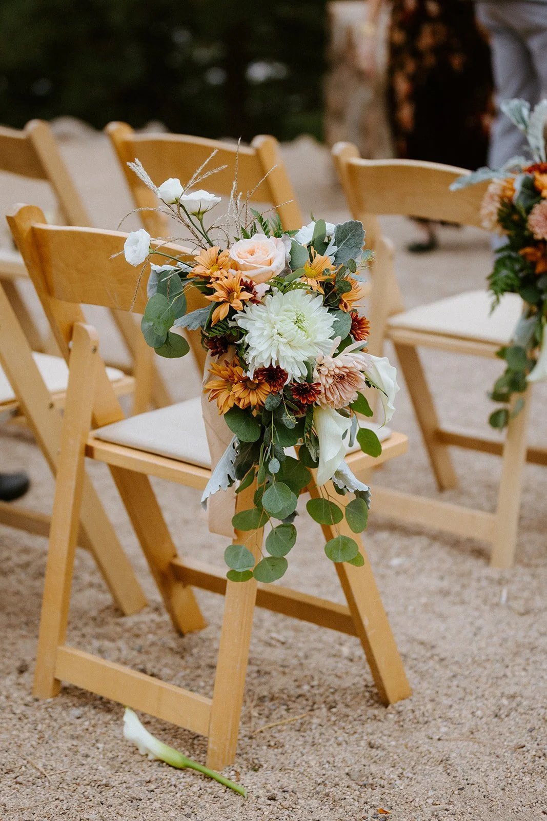A flower bouquet from Sturtz & Copeland sits on a wood folding chair during a Boulder elopement