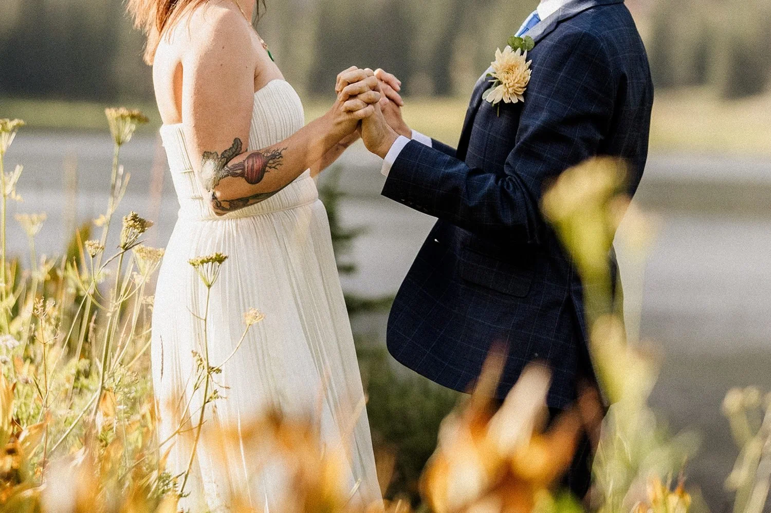 Holding hands among yellow wildflowers near Lake Irwin