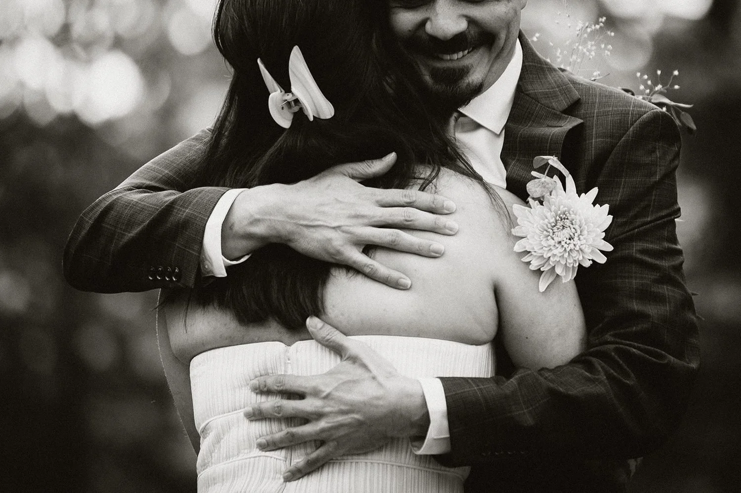 Black and white embrace during a forest first look