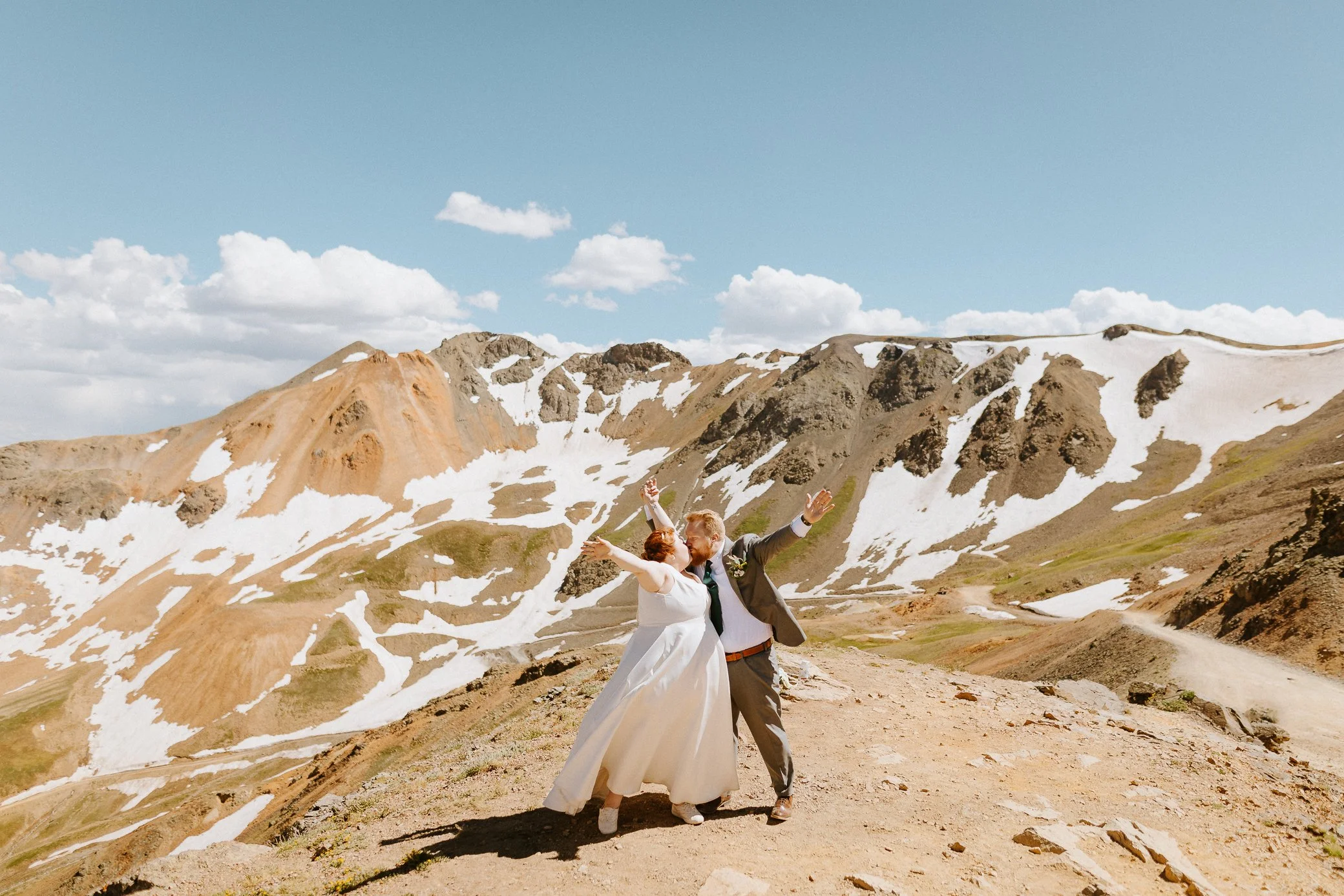 bride and groom celebrating at the top of California Pass
