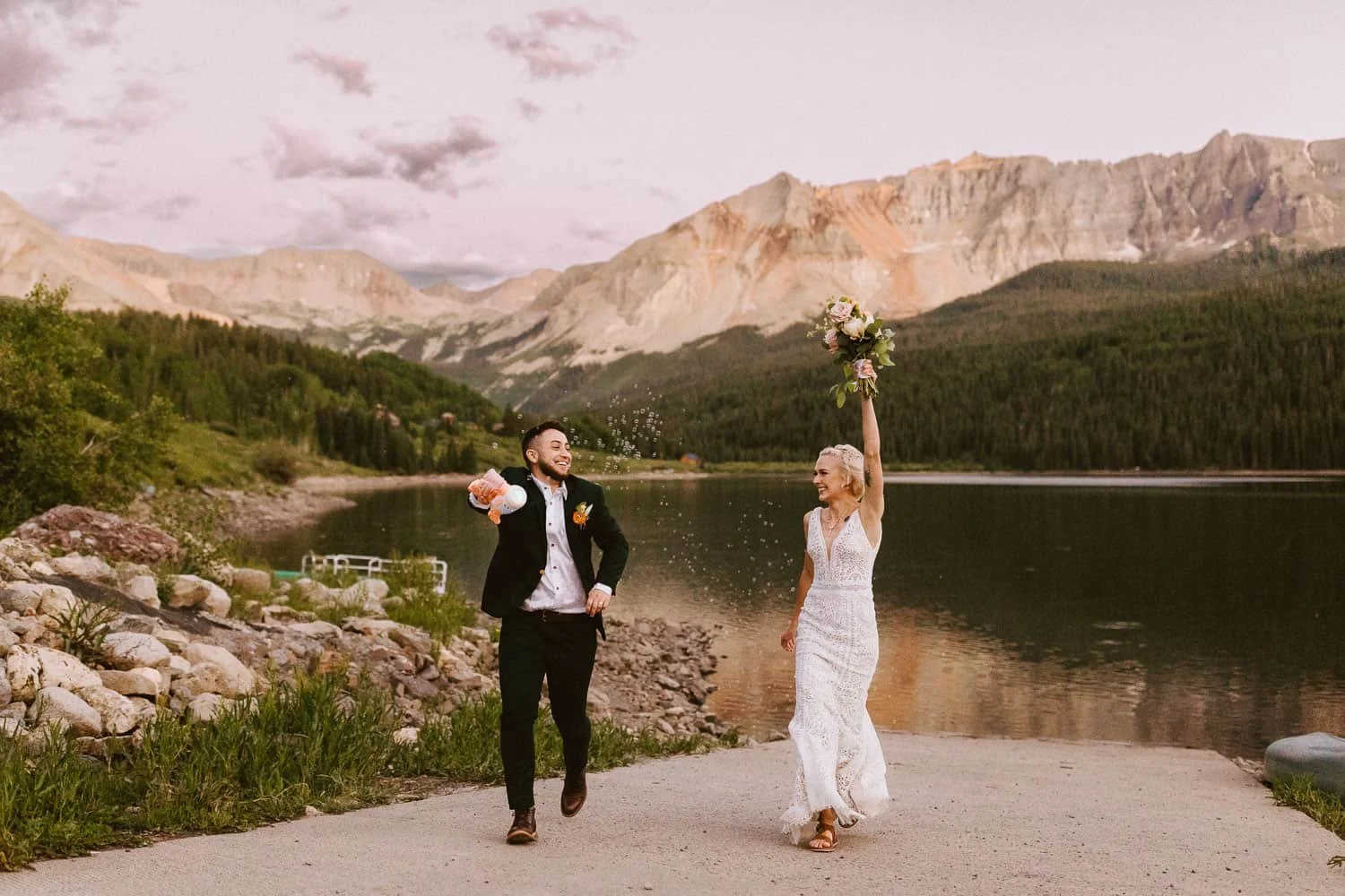 Couple celebrating their elopement beside a mountain lake near Telluride at sunset