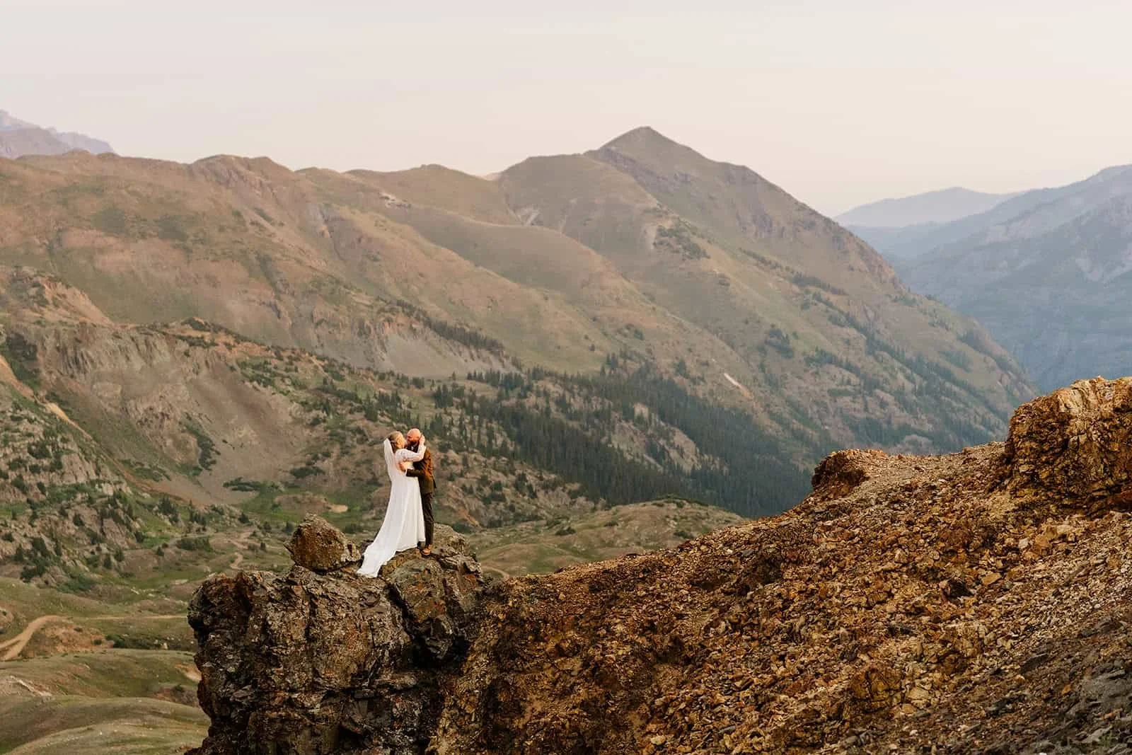 Couple standing on a rocky overlook high above the valleys near Silverton